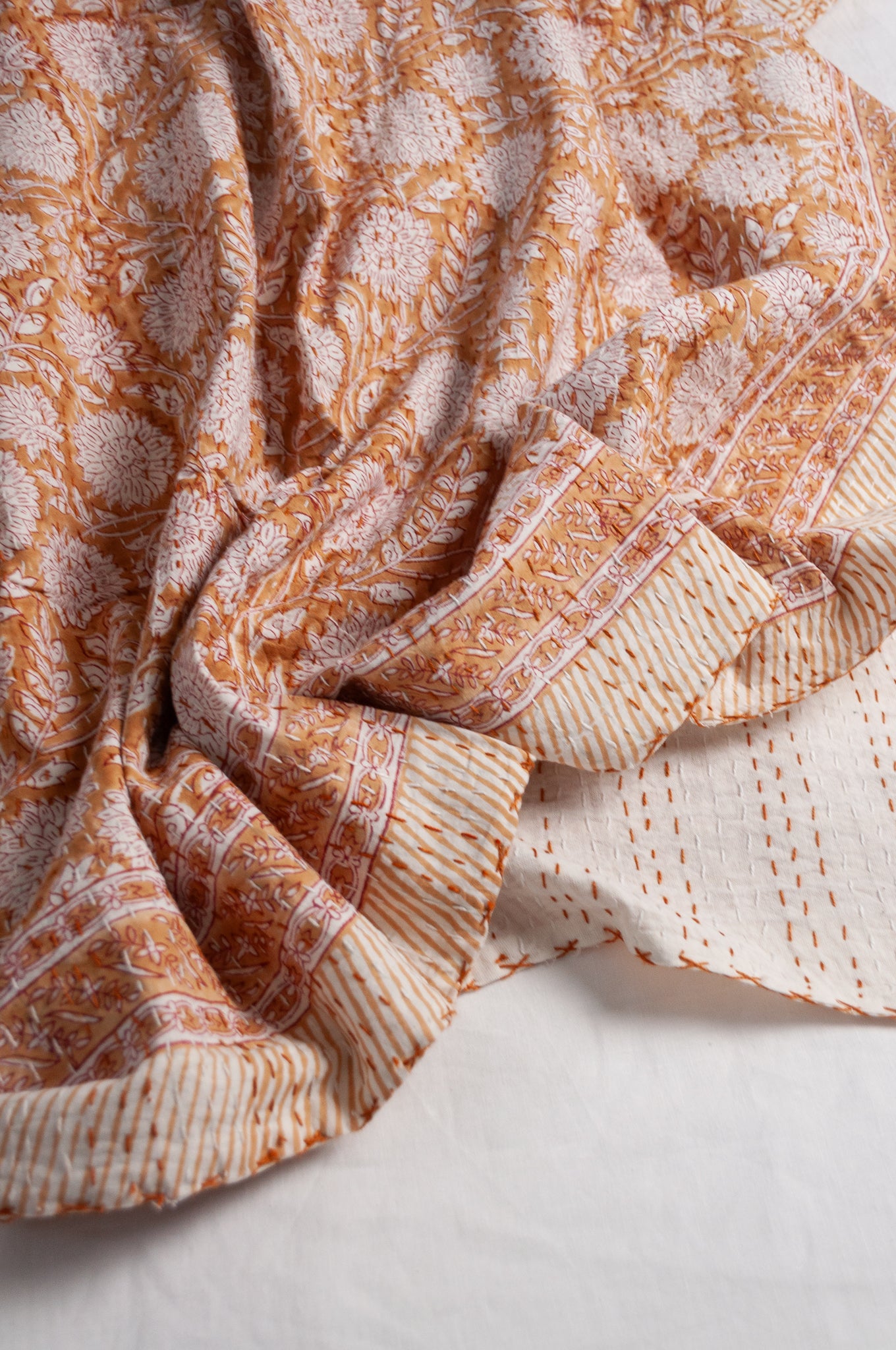Cotton kantha quilt in mustard yellow and white floral.
