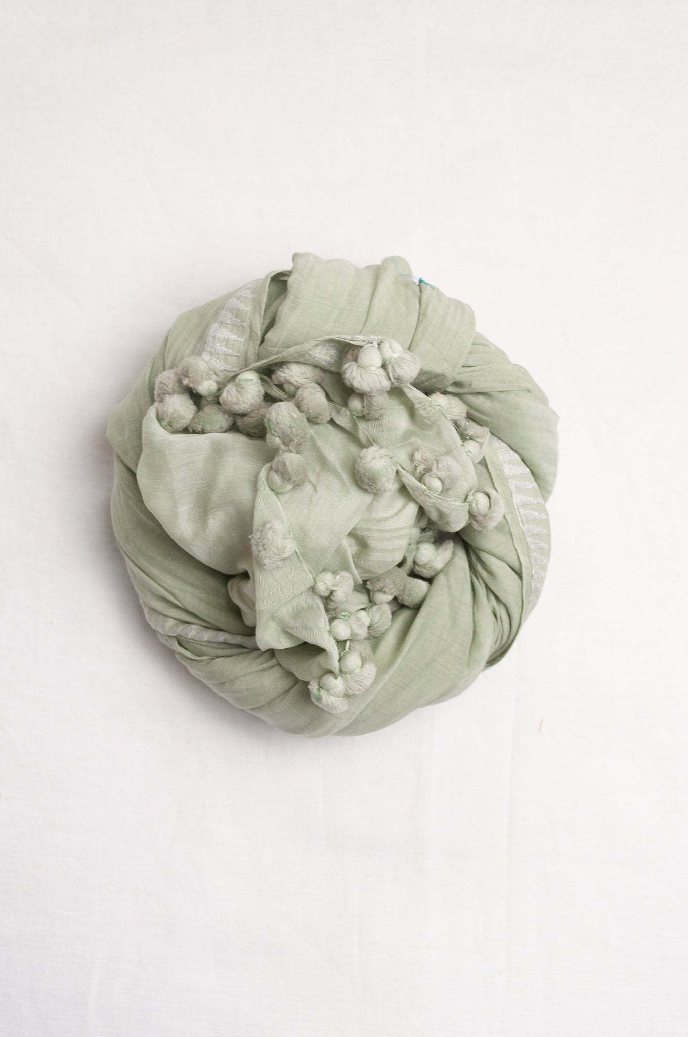 Silk cotton pom pom scarf in celadon green.