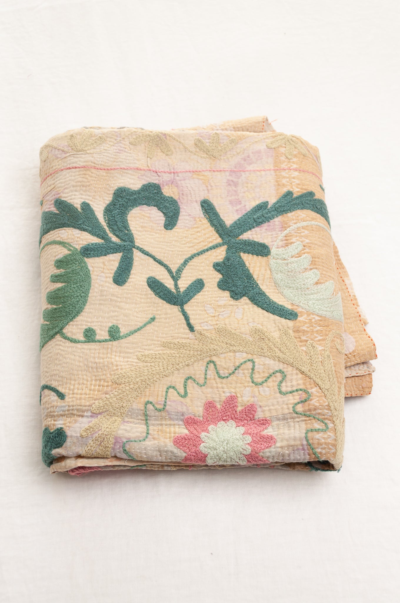 Vintage kantha quilt embroidered Suzani style floral design in teal and pink on pastel floral stripes.