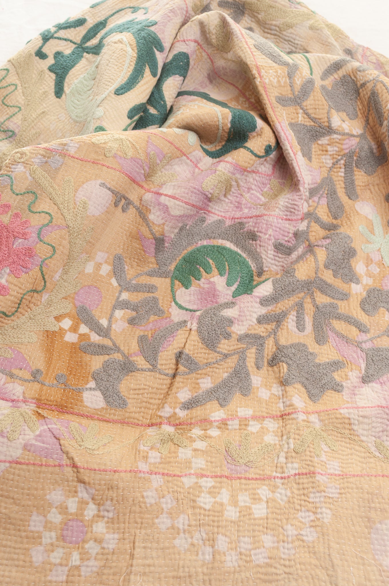 Vintage kantha quilt embroidered Suzani style floral design in teal and pink on pastel floral stripes.