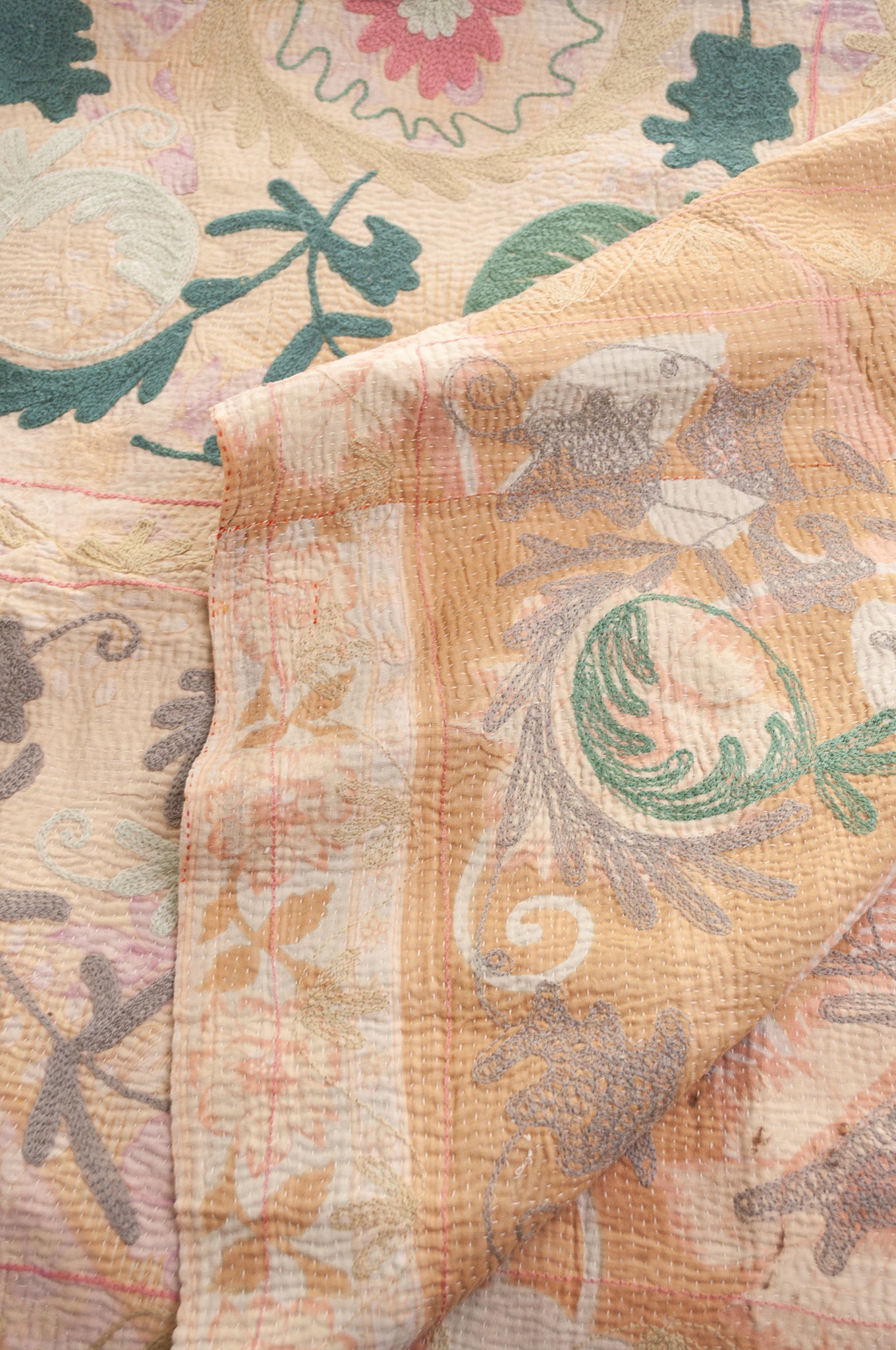 Vintage kantha quilt embroidered Suzani style floral design in teal and pink on pastel floral stripes.