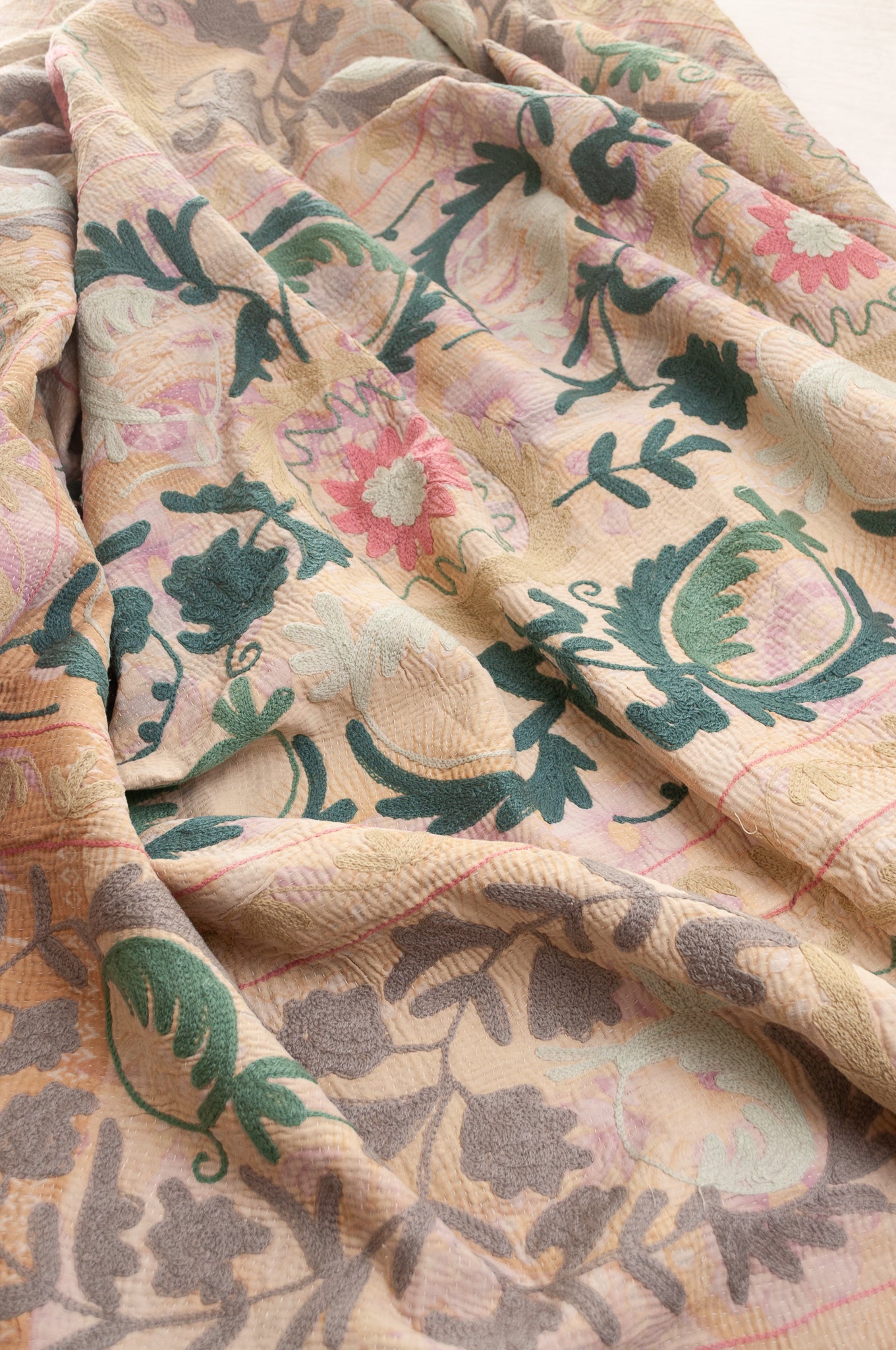 Vintage kantha quilt embroidered Suzani style floral design in teal and pink on pastel floral stripes.