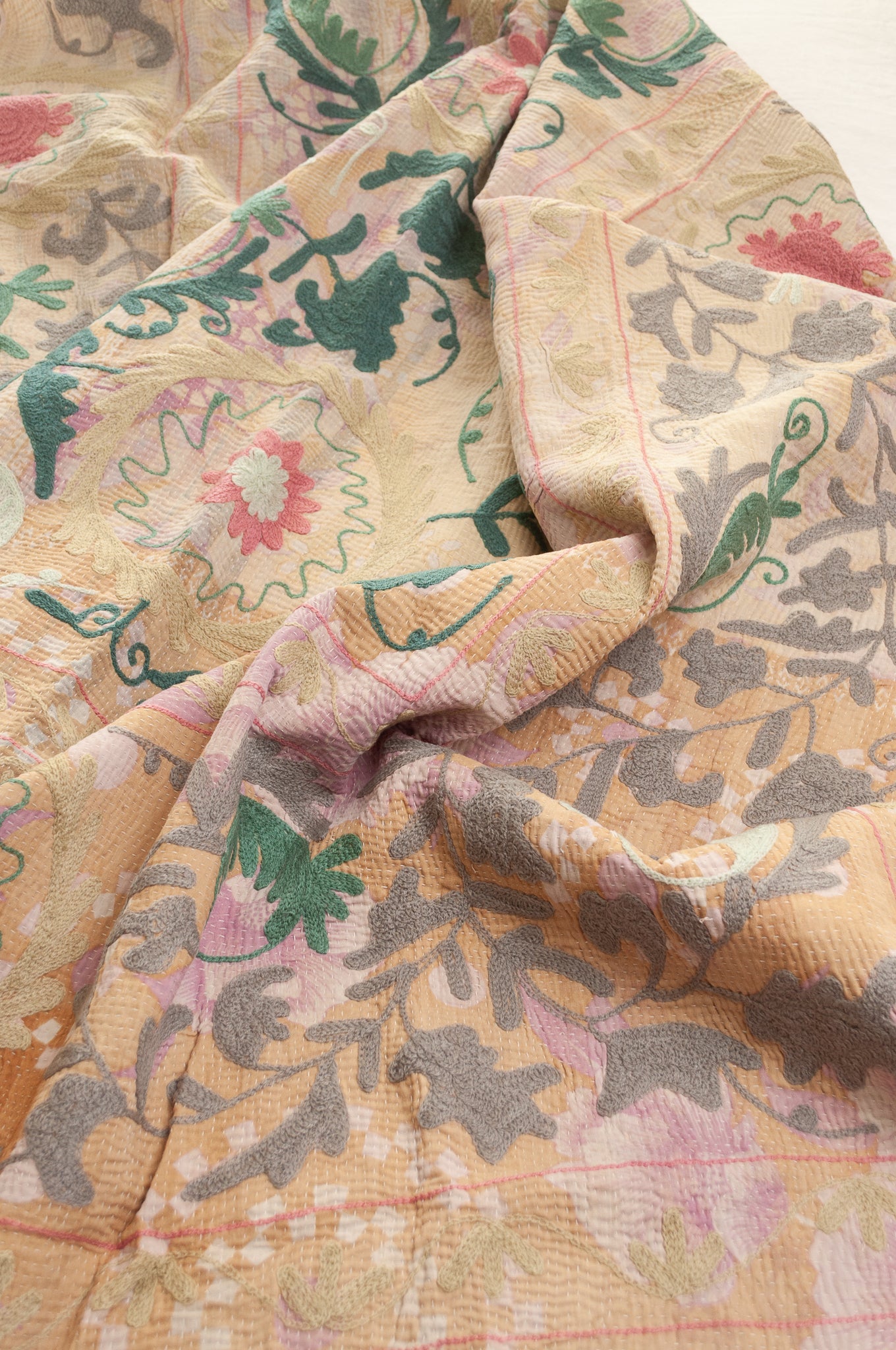 Vintage kantha quilt embroidered Suzani style floral design in teal and pink on pastel floral stripes.
