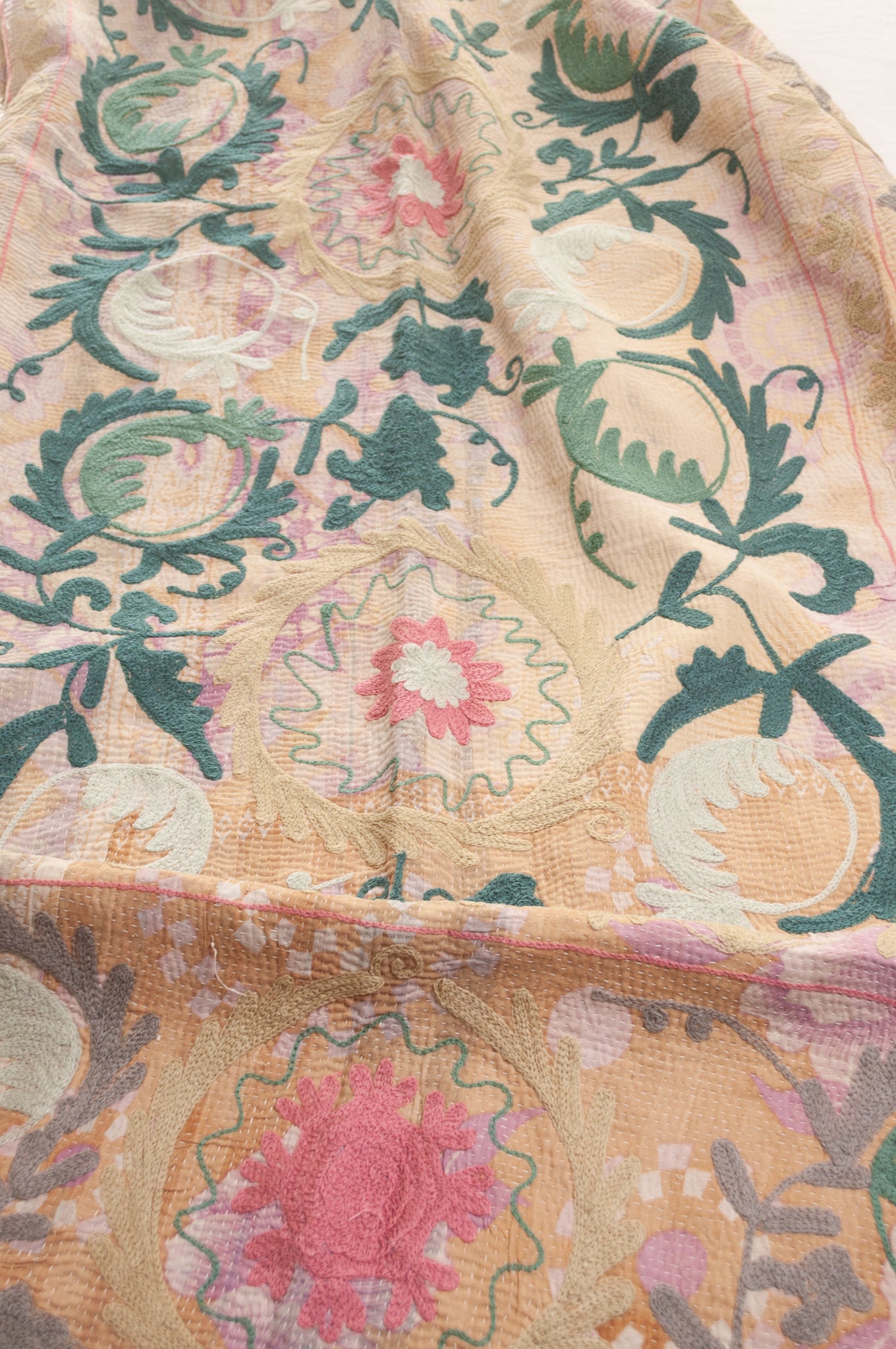 Vintage kantha quilt embroidered Suzani style floral design in teal and pink on pastel floral stripes.