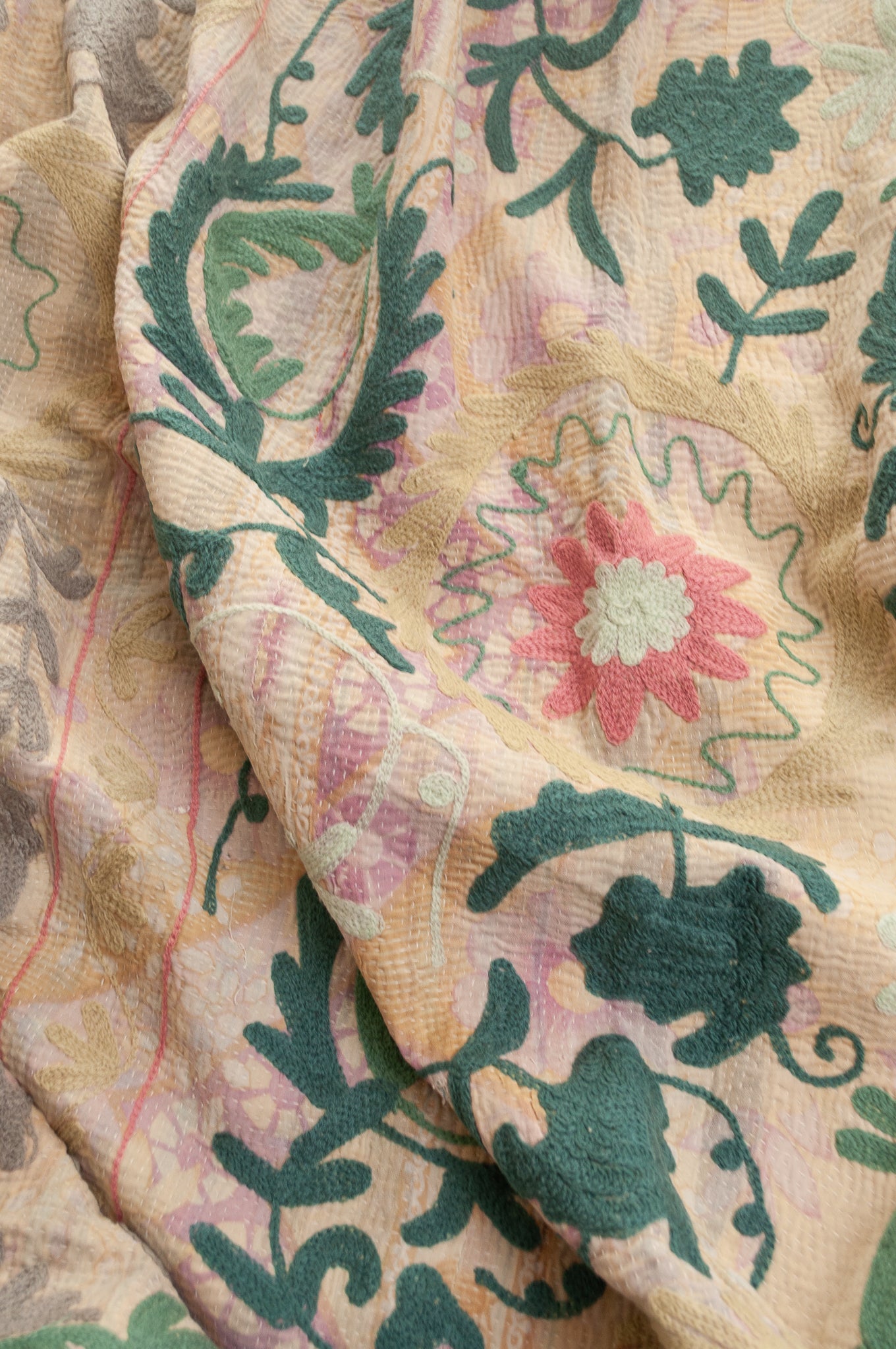 Vintage kantha quilt embroidered Suzani style floral design in teal and pink on pastel floral stripes.