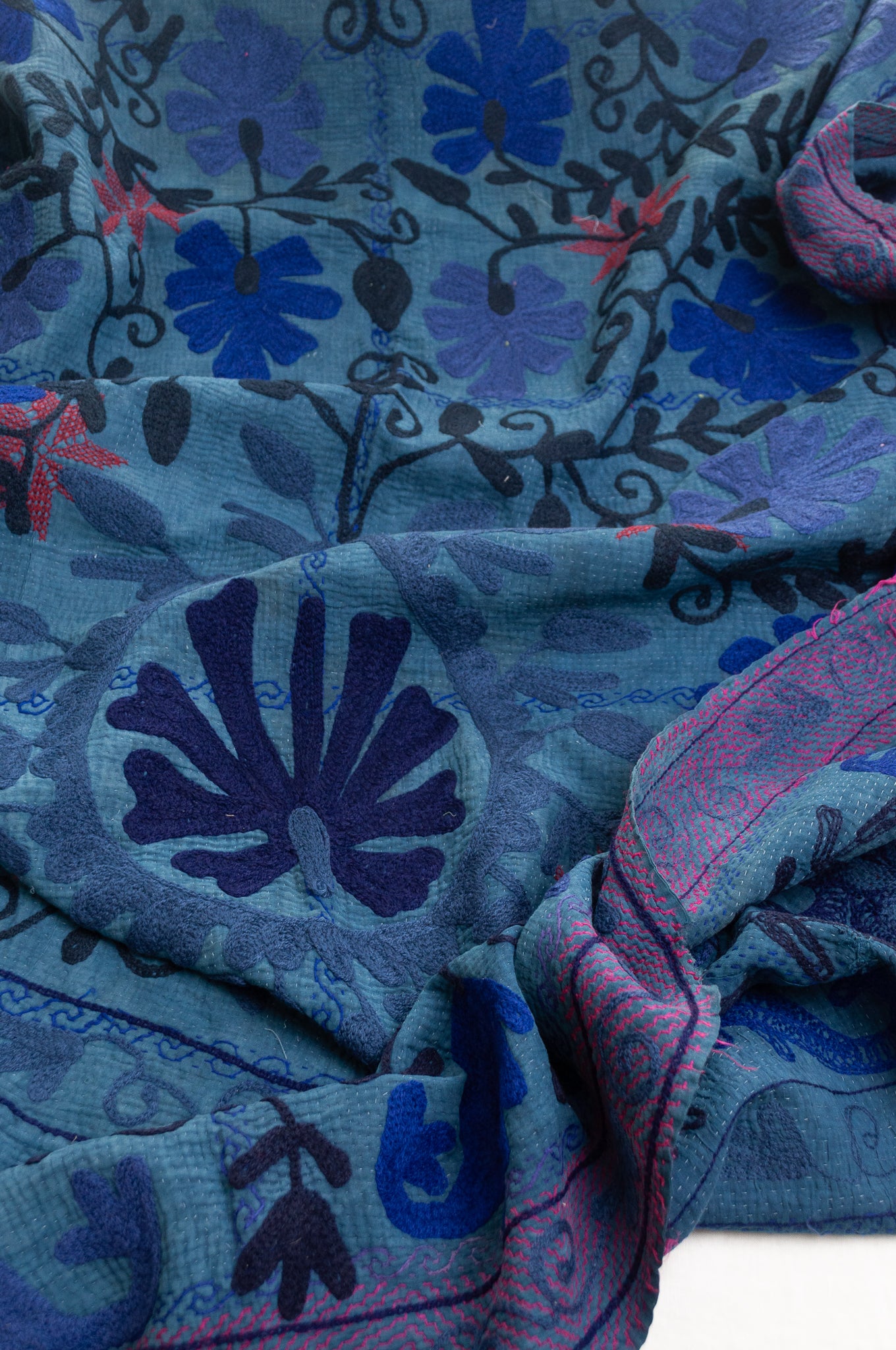 Vintage indigo kantha quilt embroidered Suzani style in shades of indigo with red highlights.