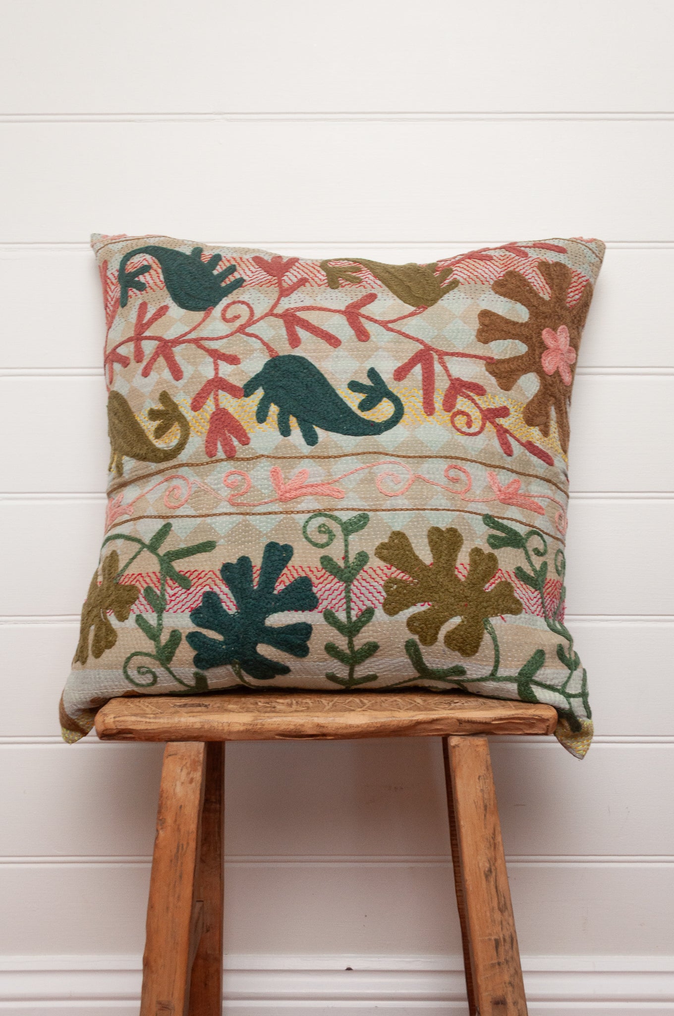 Suzani embroidered vintage kantha quilt cushion, teal rust olive green and mustard on pastel background.