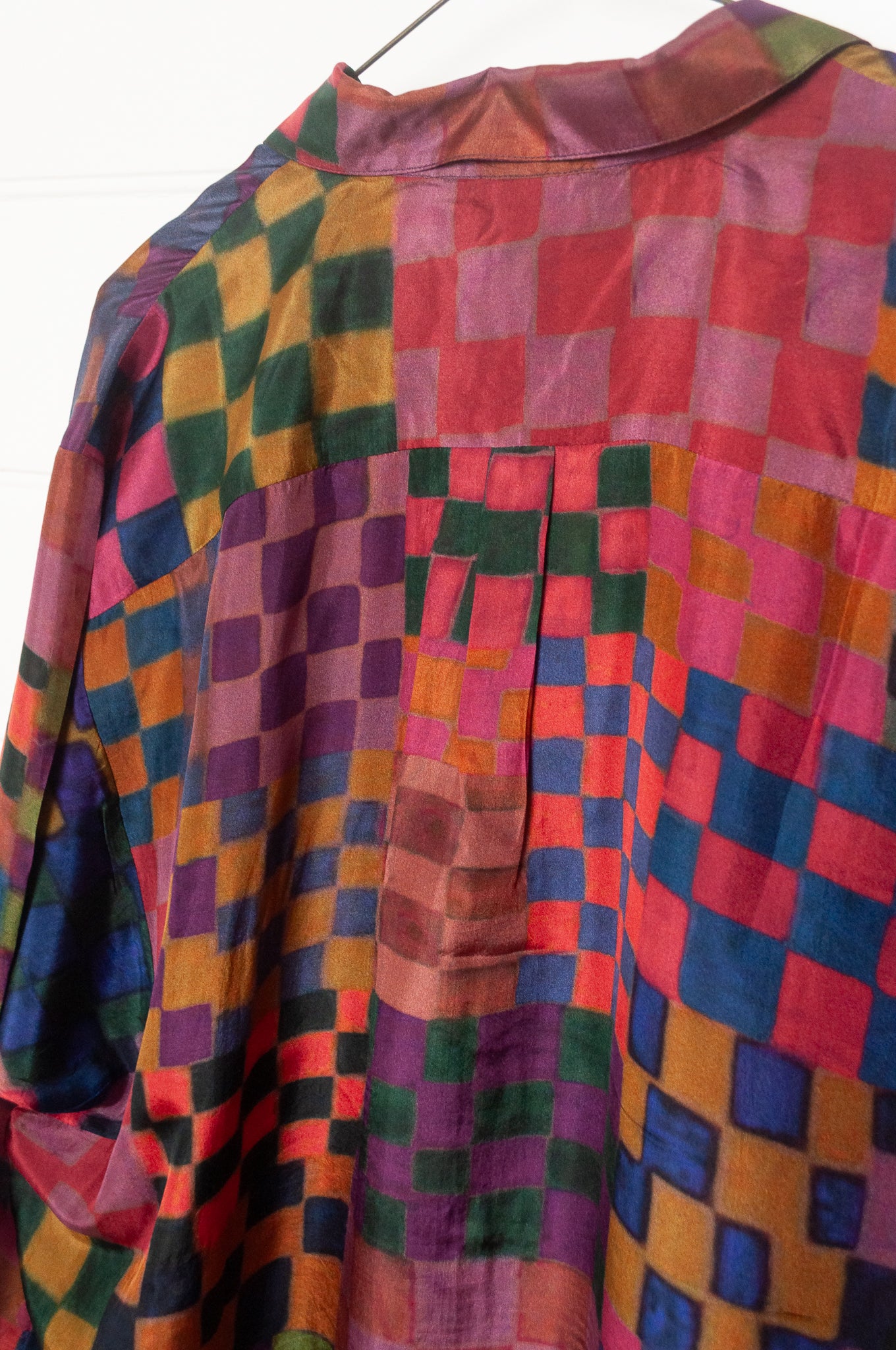 Neeru Kumar pure silk digital print button up long-sleeved blouse with a geometric checkerboard pattern in shades of burgundy, magenta, olive, blue, brown, and black.