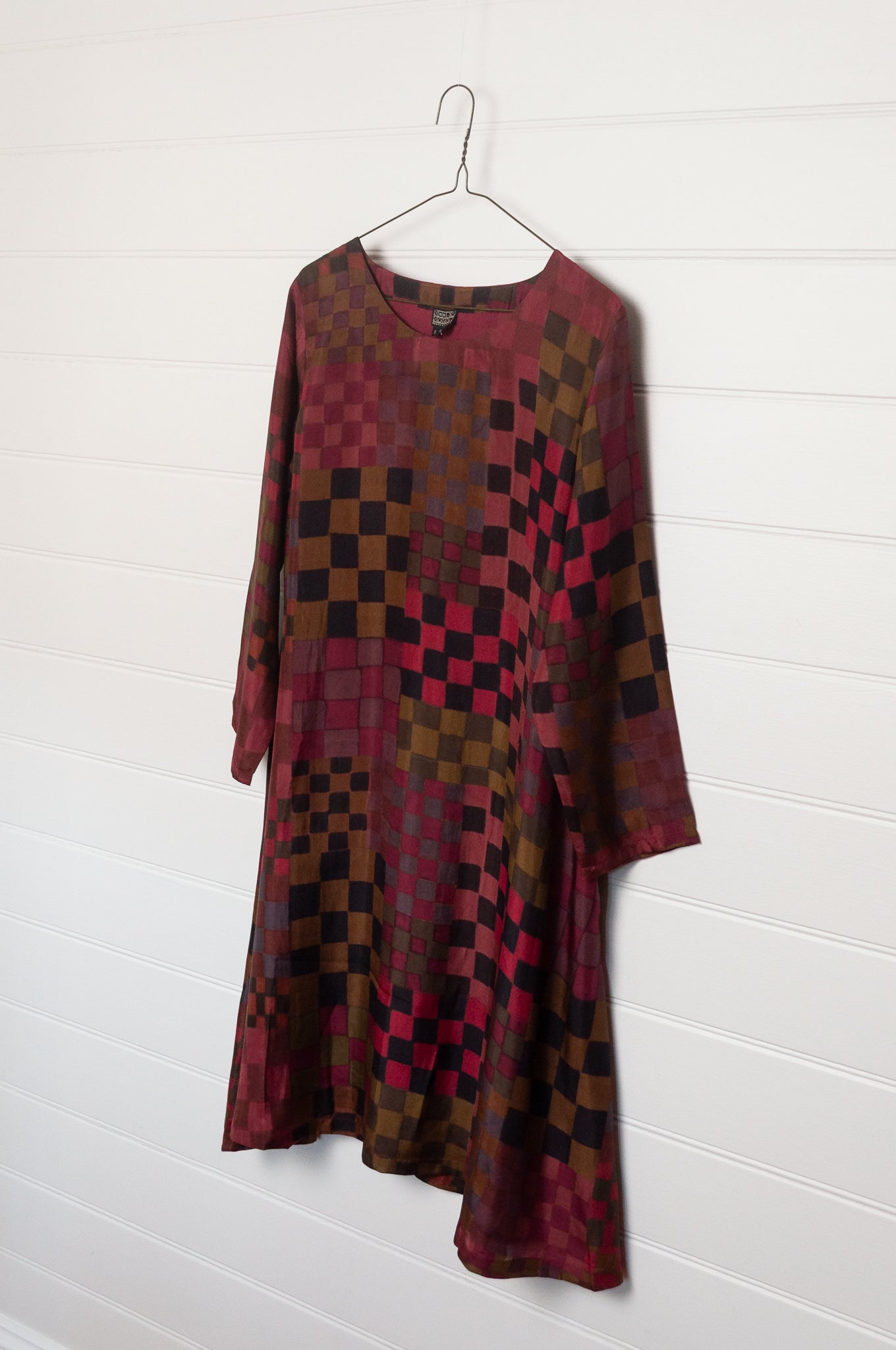 Neeru Kumar pure silk digital print A-line long-sleeved tunic dress with a geometric checkerboard pattern in shades of burgundy, magenta, brown, and black.