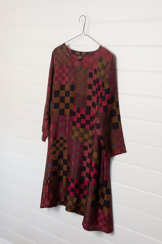 Neeru Kumar pure silk digital print A-line long-sleeved tunic dress with a geometric checkerboard pattern in shades of burgundy, magenta, brown, and black.