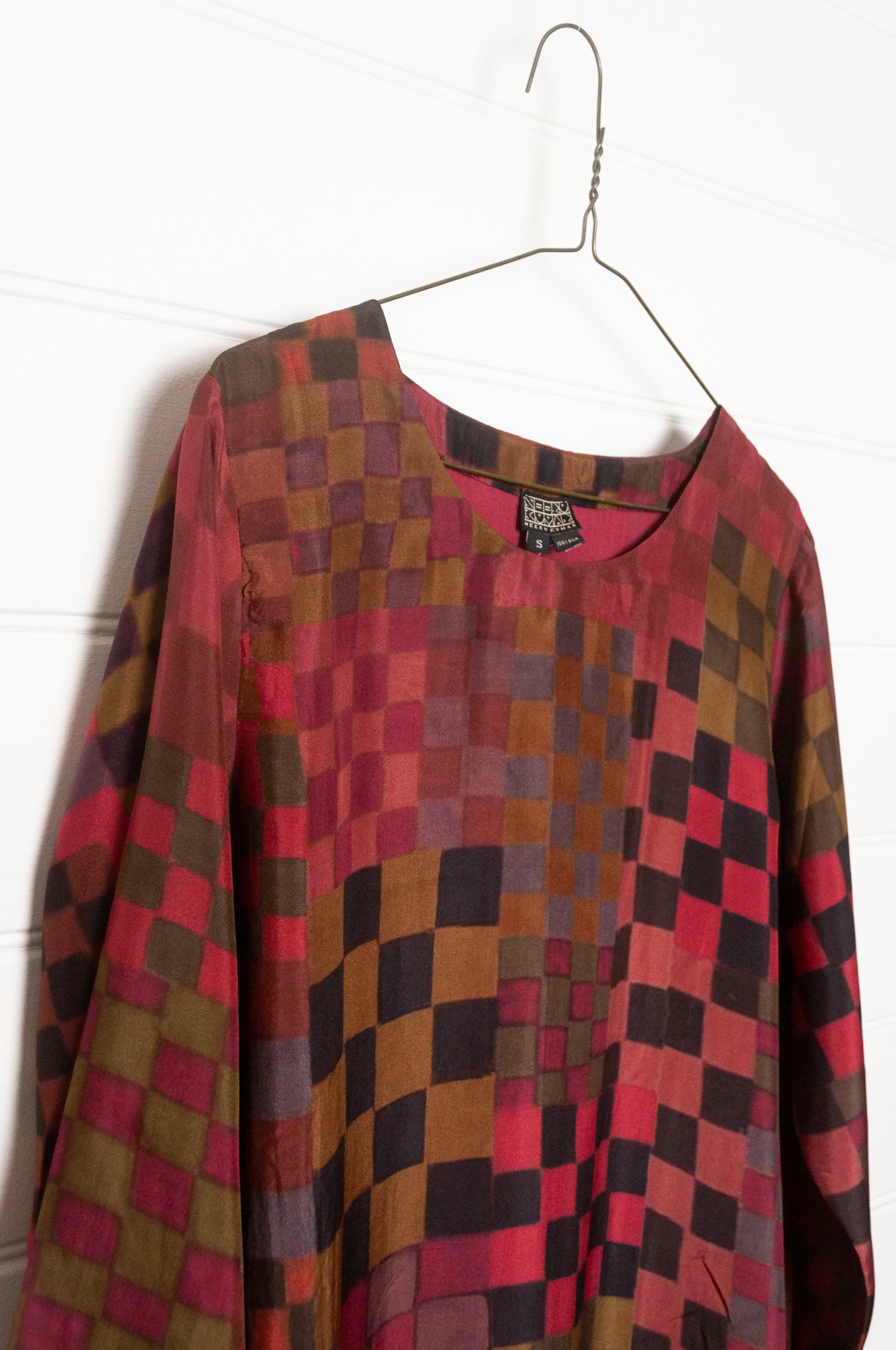 Neeru Kumar pure silk digital print A-line long-sleeved tunic dress with a geometric checkerboard pattern in shades of burgundy, magenta, brown, and black.