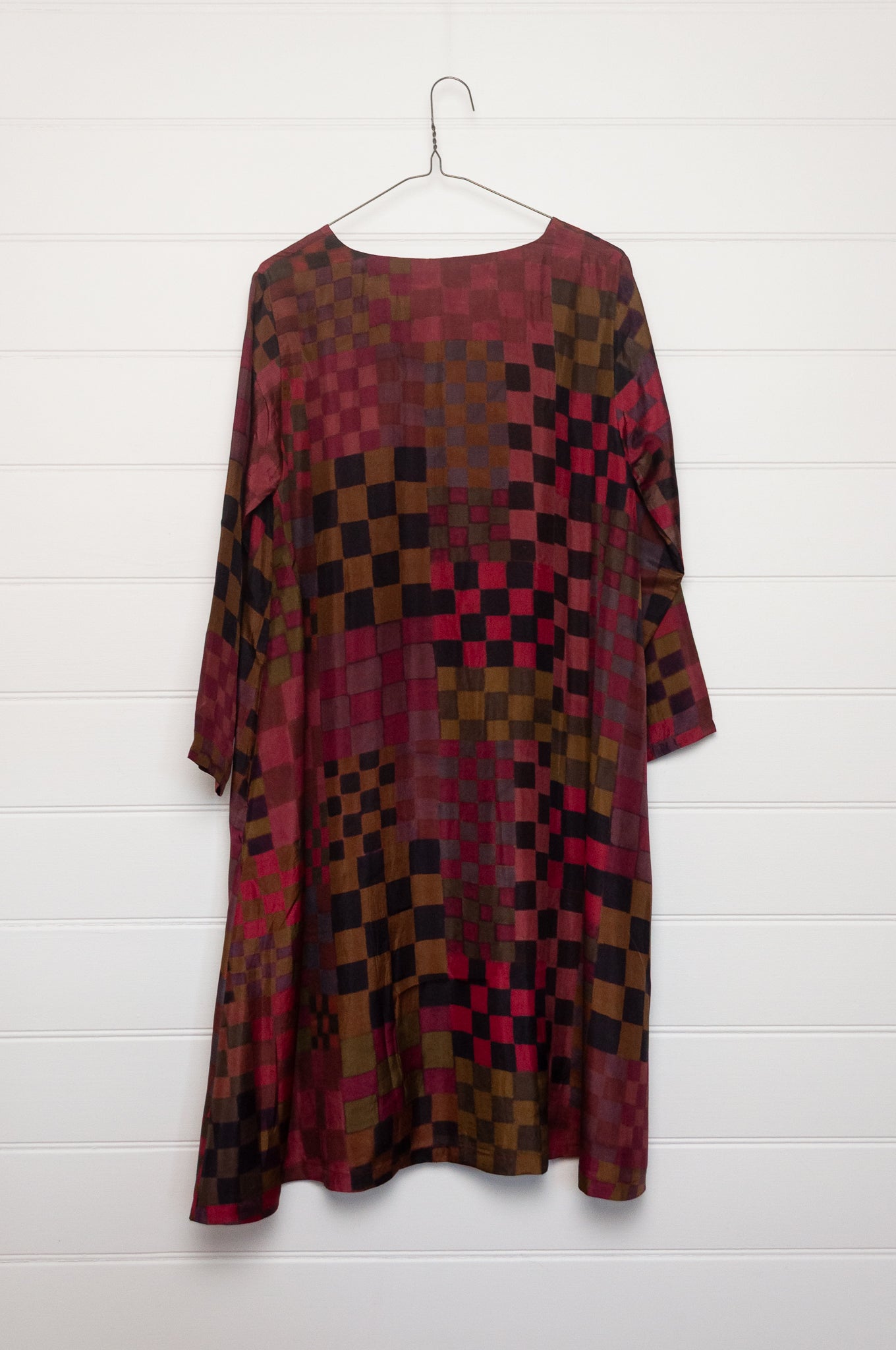 Neeru Kumar pure silk digital print A-line long-sleeved tunic dress with a geometric checkerboard pattern in shades of burgundy, magenta, brown, and black.