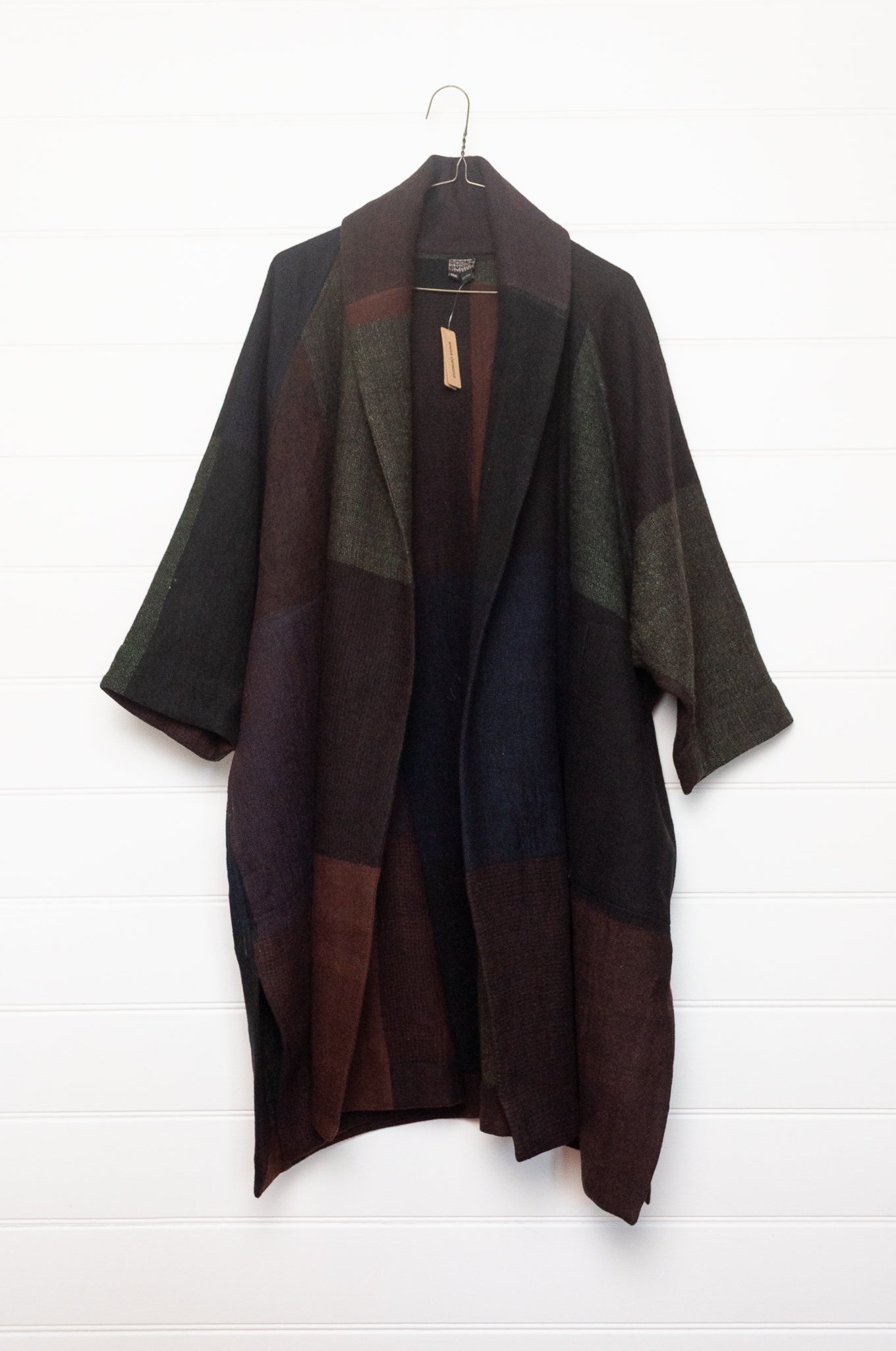 Neeru Kumar handwoven wool cardigan jacket coat in multicolor block pattern of charcoal, brown, aubergine purple, and black.