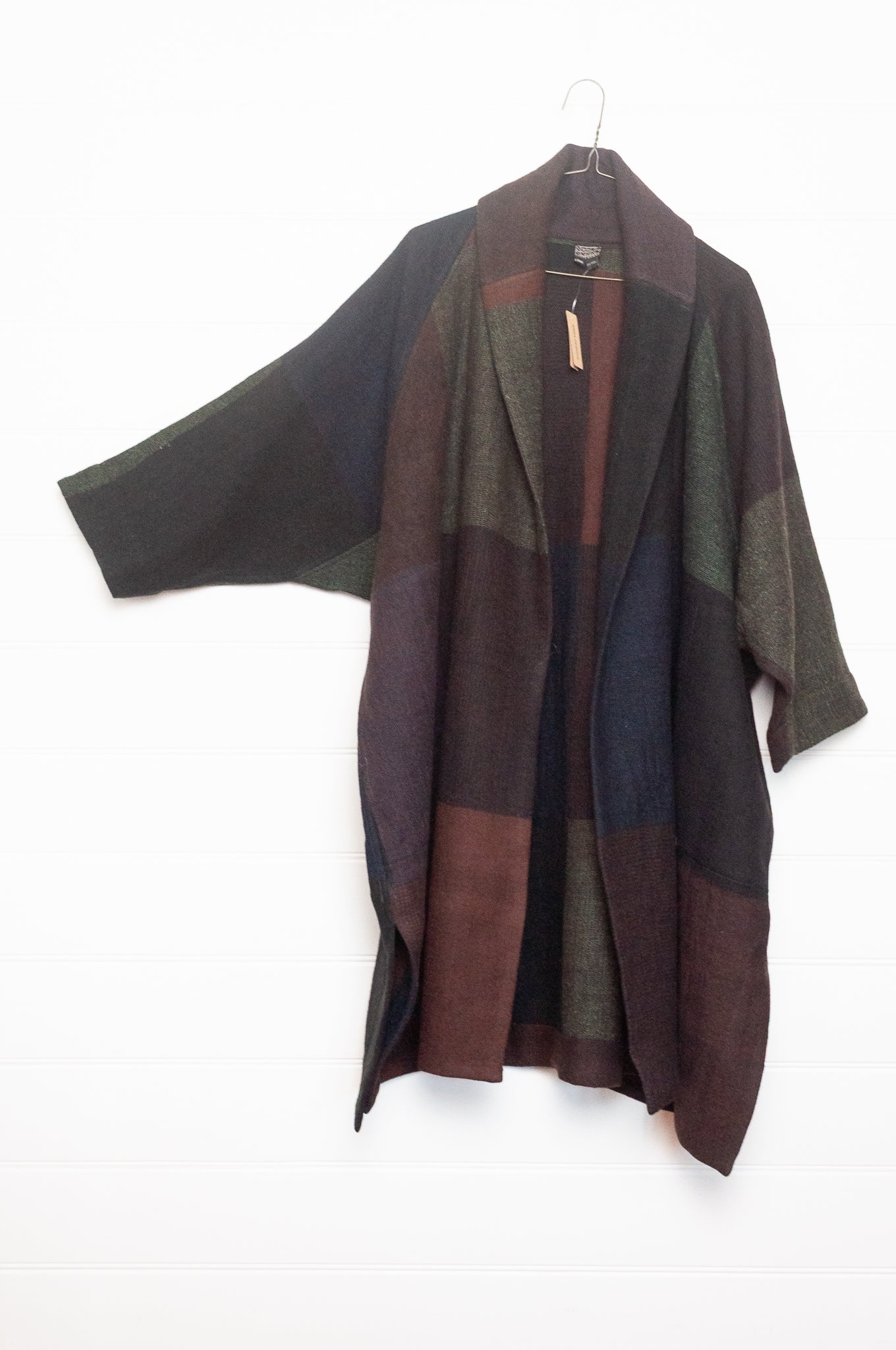Neeru Kumar handwoven wool cardigan jacket coat in multicolor block pattern of charcoal, brown, aubergine purple, and black.