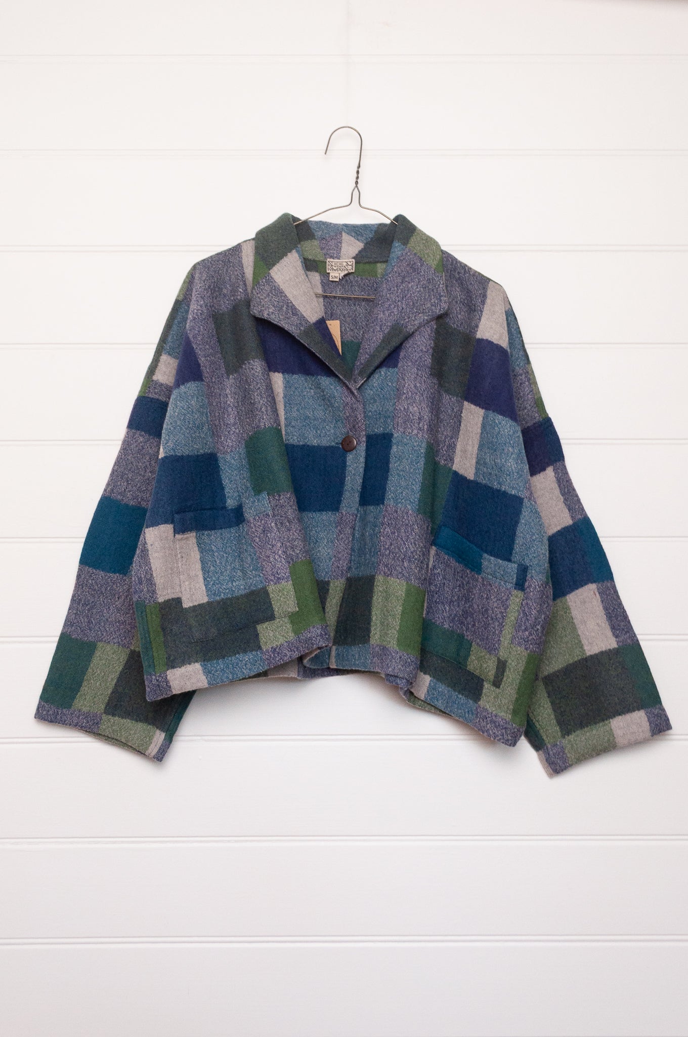 Neeru Kumar handwoven wool Coco jacket with a geometric blanket block pattern in shades of blue, green, gray, and beige