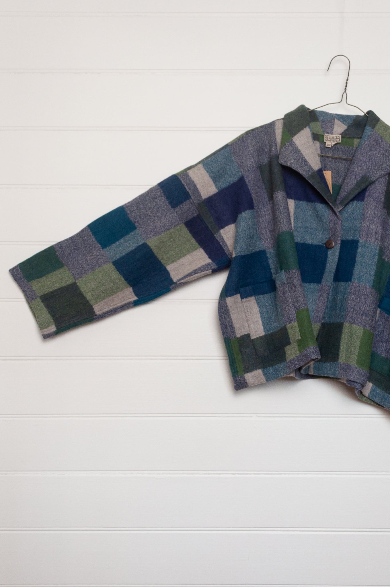 Neeru Kumar handwoven wool Coco jacket with a geometric blanket block pattern in shades of blue, green, gray, and beige