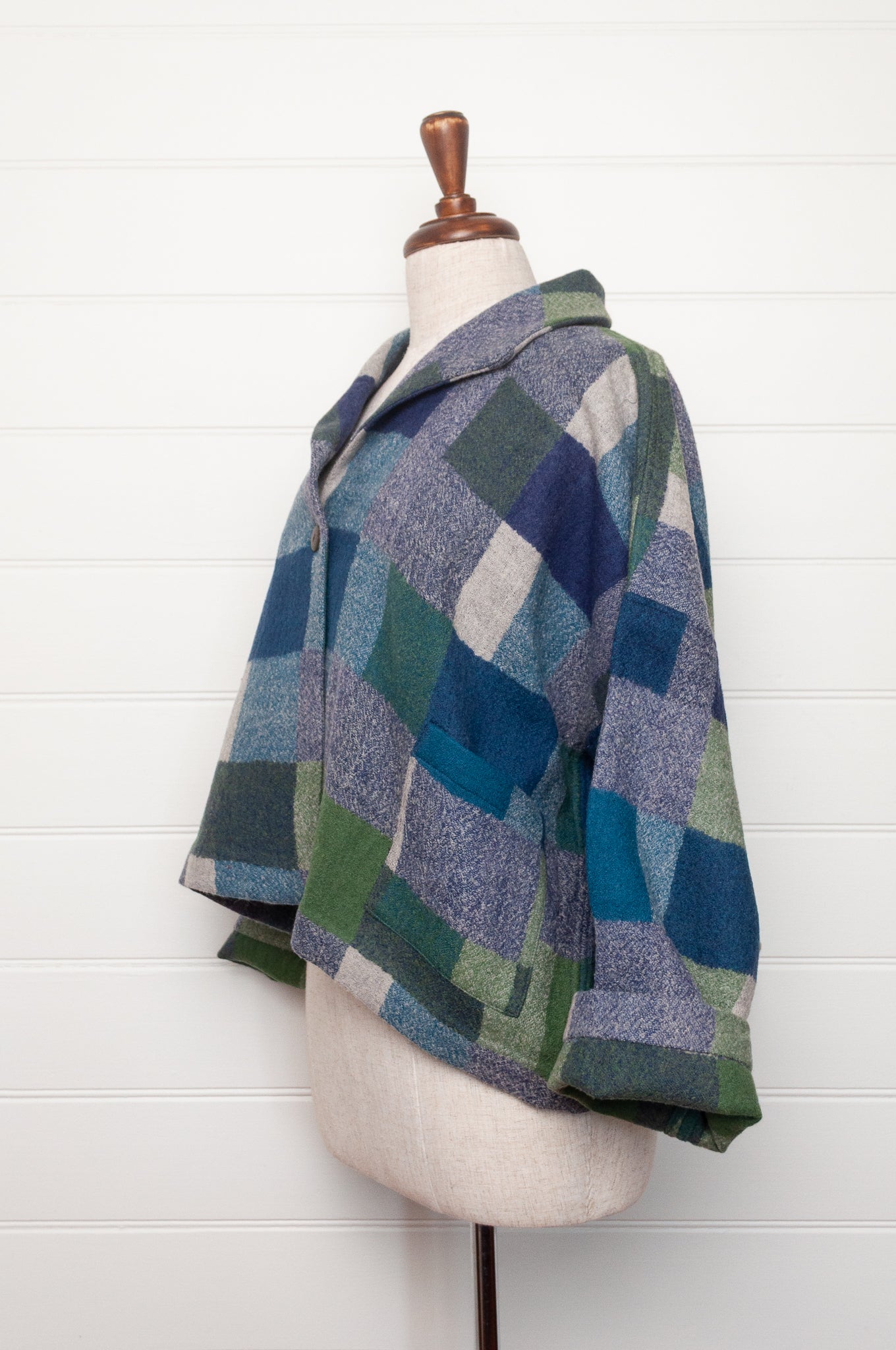 Neeru Kumar handwoven wool Coco jacket with a geometric blanket block pattern in shades of blue, green, gray, and beige