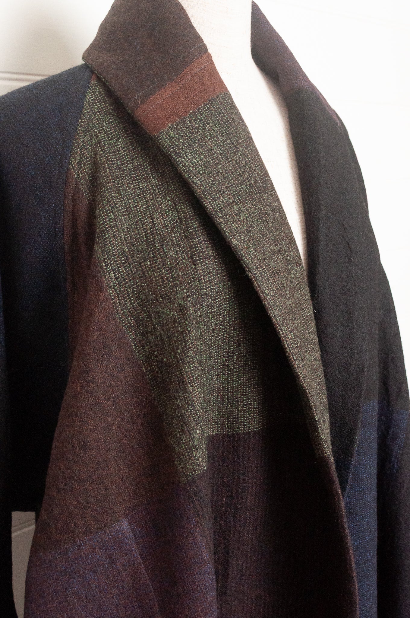 Neeru Kumar handwoven wool cardigan jacket coat in multicolor block pattern of charcoal, brown, aubergine purple, and black.