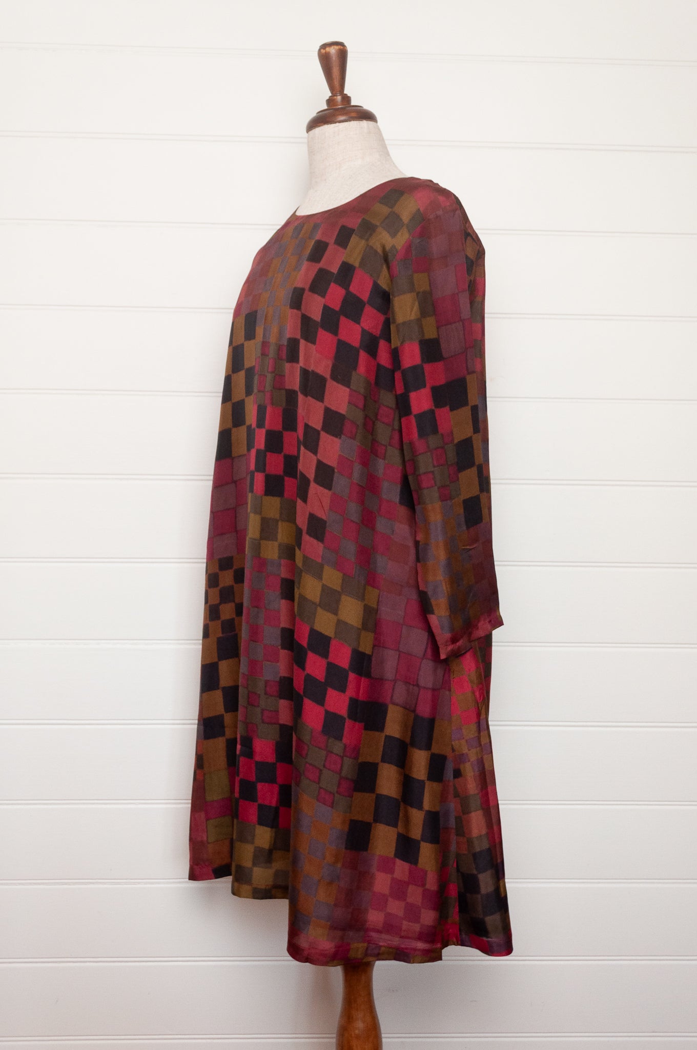 Neeru Kumar pure silk digital print A-line long-sleeved tunic dress with a geometric checkerboard pattern in shades of burgundy, magenta, brown, and black.