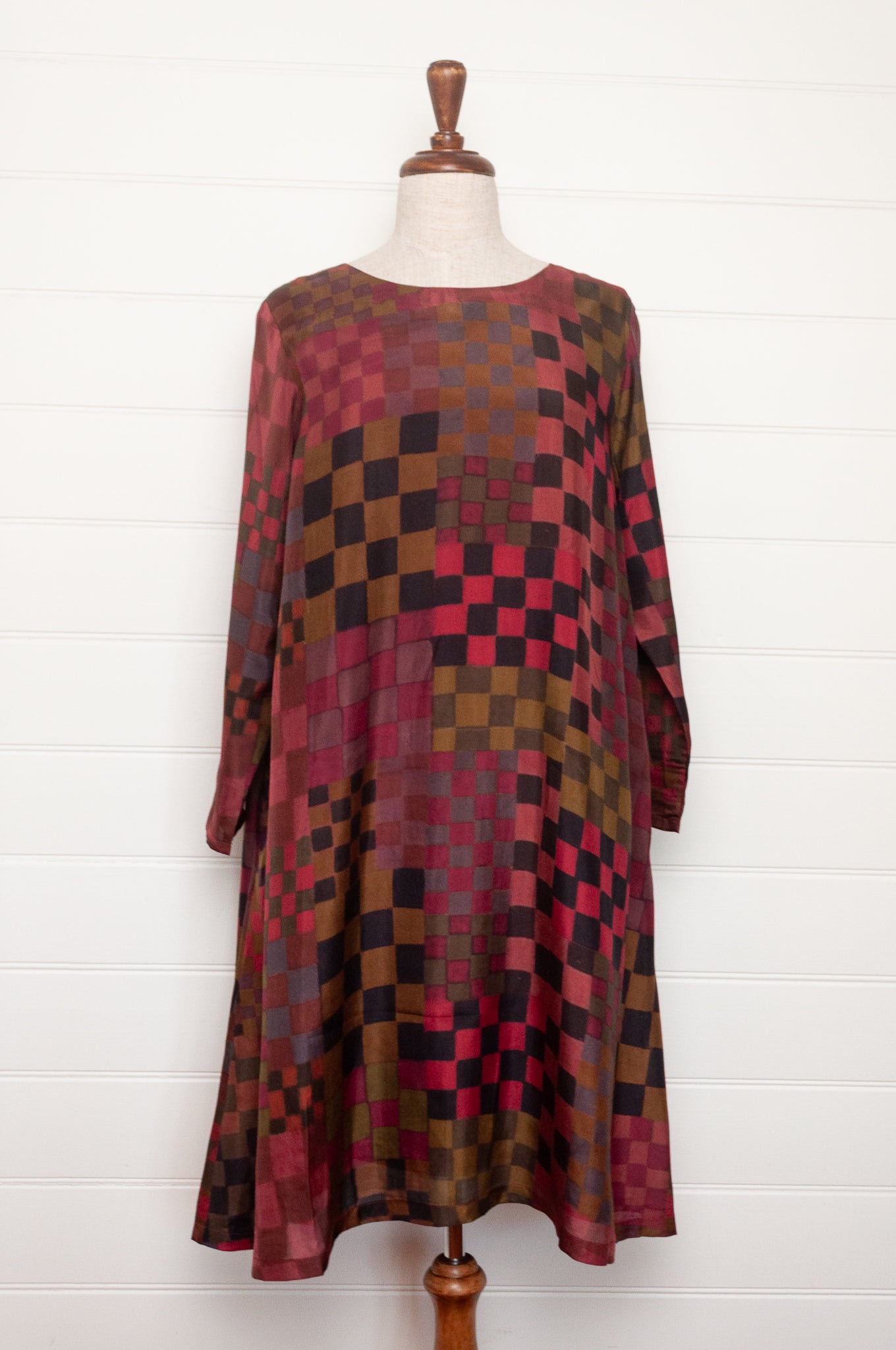 Neeru Kumar pure silk digital print A-line long-sleeved tunic dress with a geometric checkerboard pattern in shades of burgundy, magenta, brown, and black.
