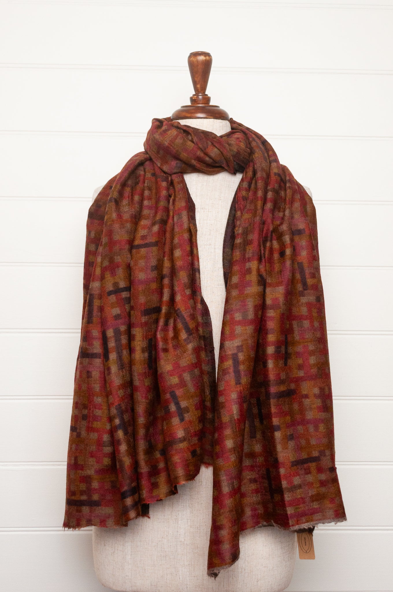 Neeru Kumar superfine wool scarf digital print check pattern in rust red, brown, and dark charcoal gray.