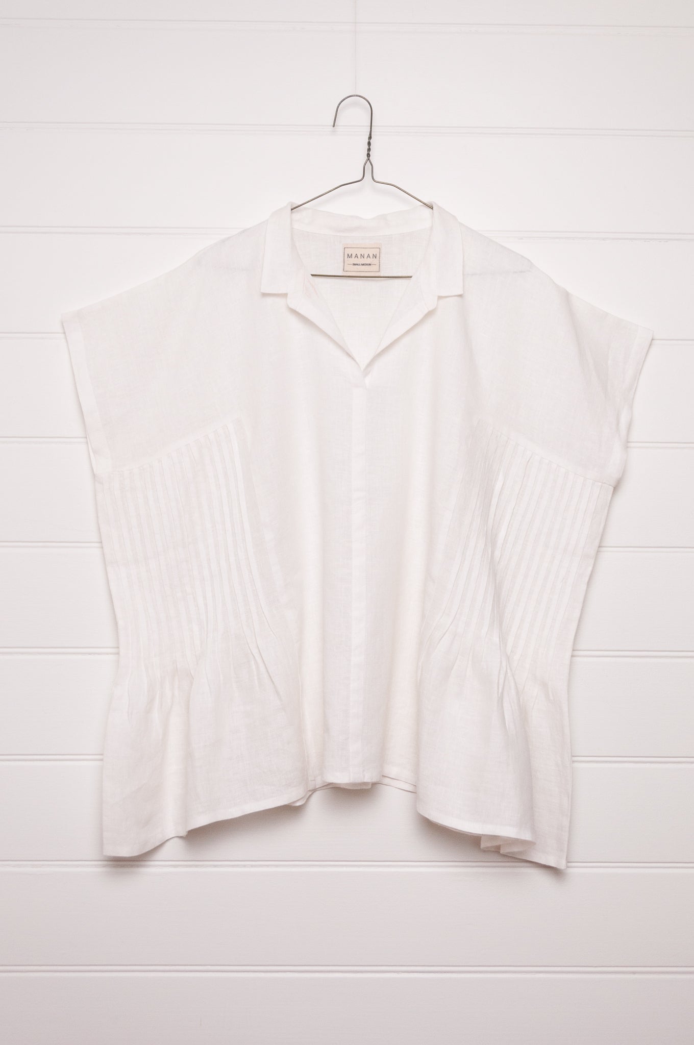 Manan Bonnie loose-fitting button up top with side pleat detailing in white linen.
