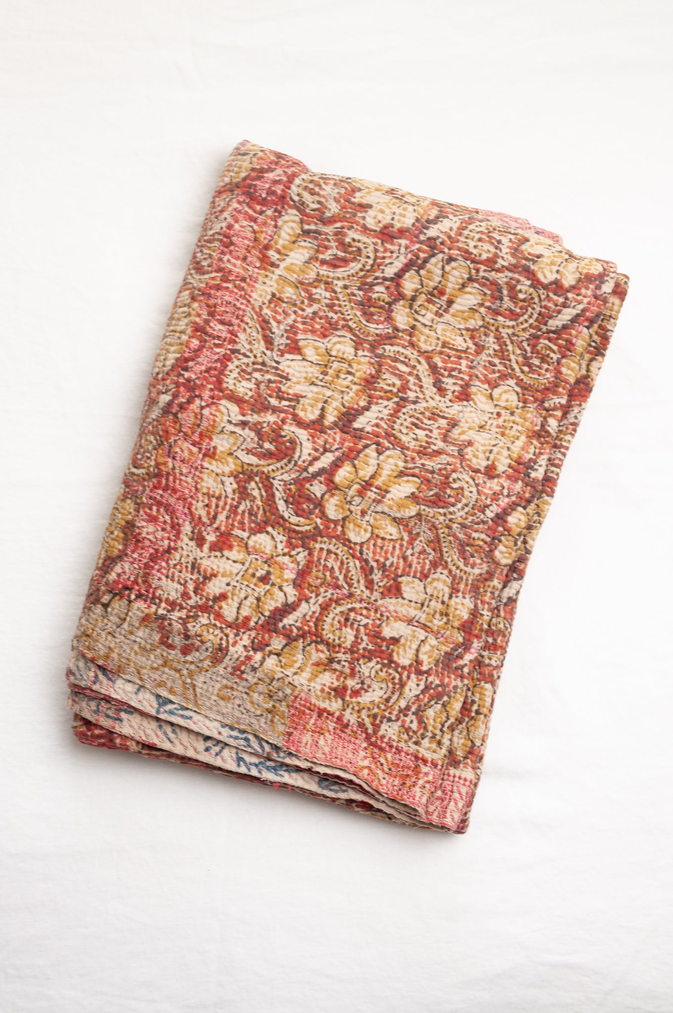Vintage bagru blockprinted kantha quilt, floral design in rust red and mustard yellow, with red traditional decorative embroidery