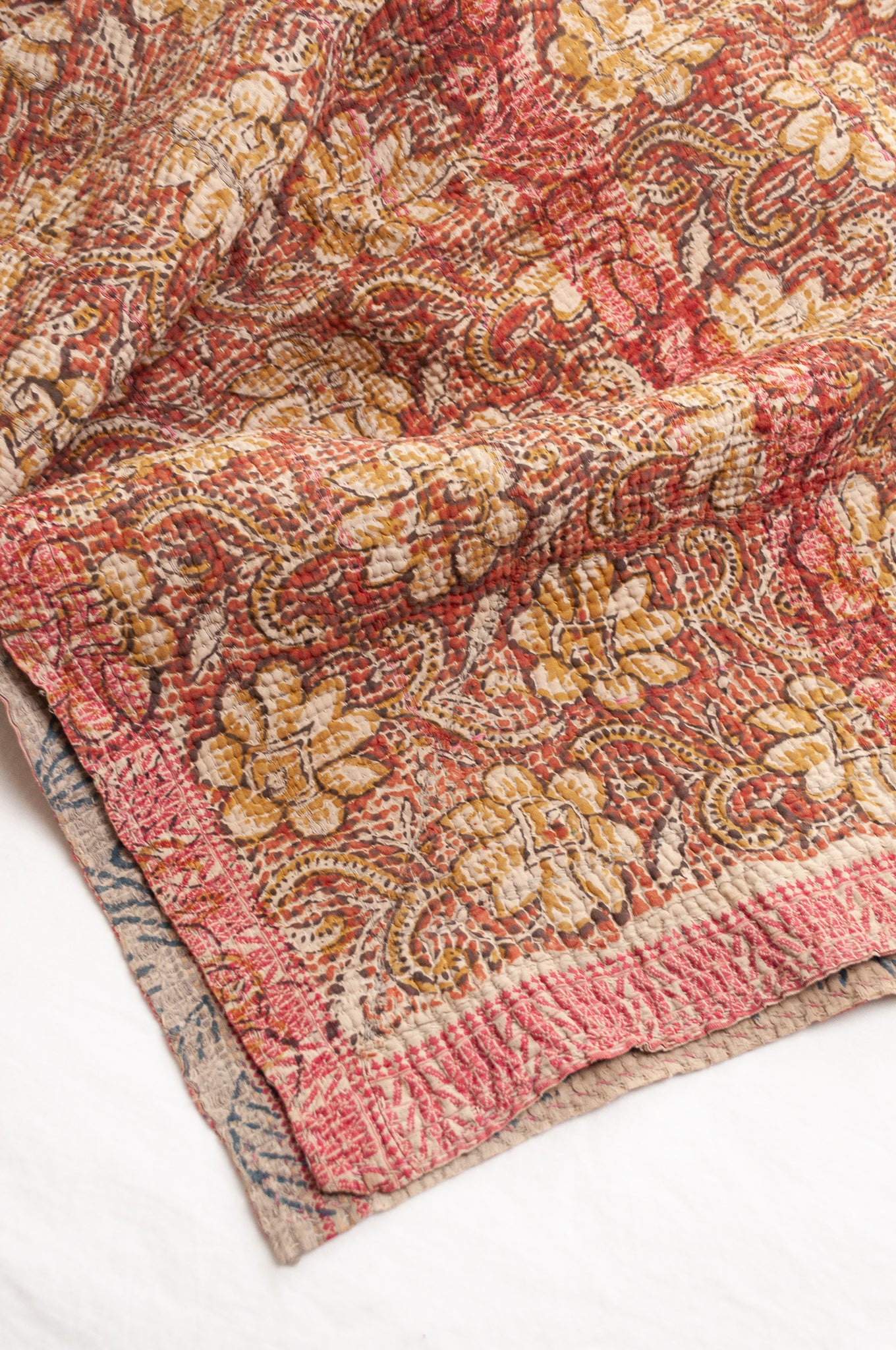 Vintage bagru blockprinted kantha quilt, floral design in rust red and mustard yellow, with red traditional decorative embroidery
