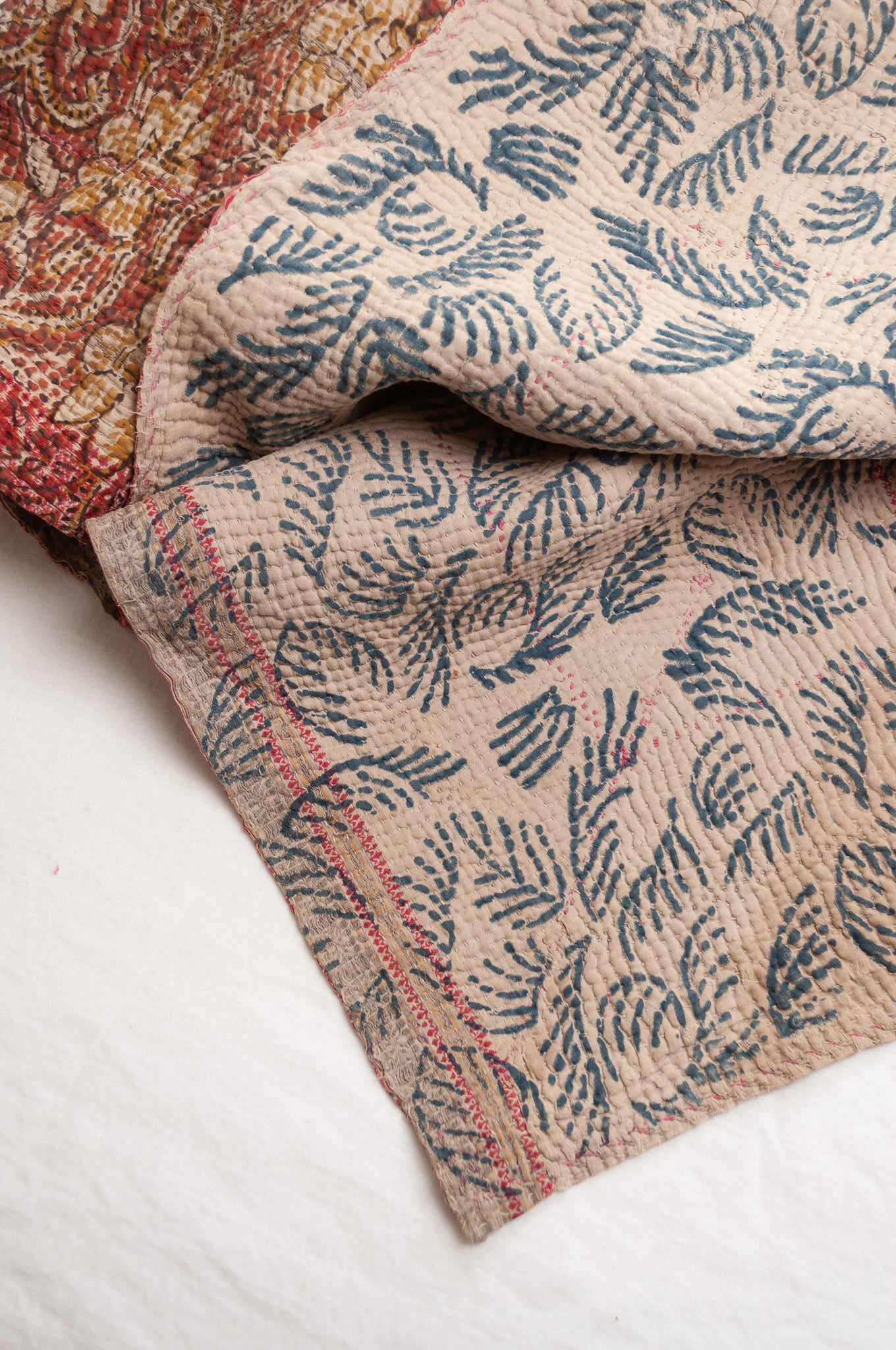 Vintage bagru blockprinted kantha quilt, floral design in rust red and mustard yellow, with red traditional decorative embroidery