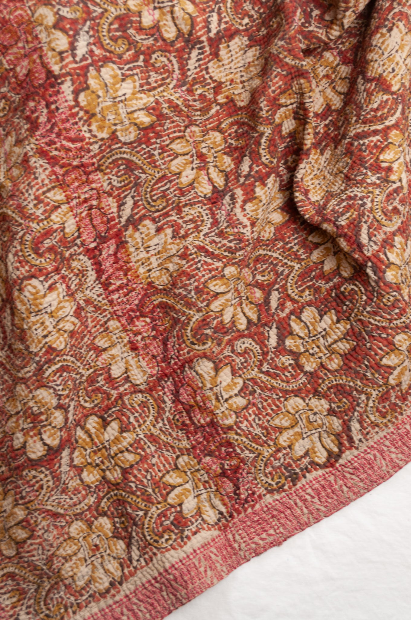 Vintage bagru blockprinted kantha quilt, floral design in rust red and mustard yellow, with red traditional decorative embroidery