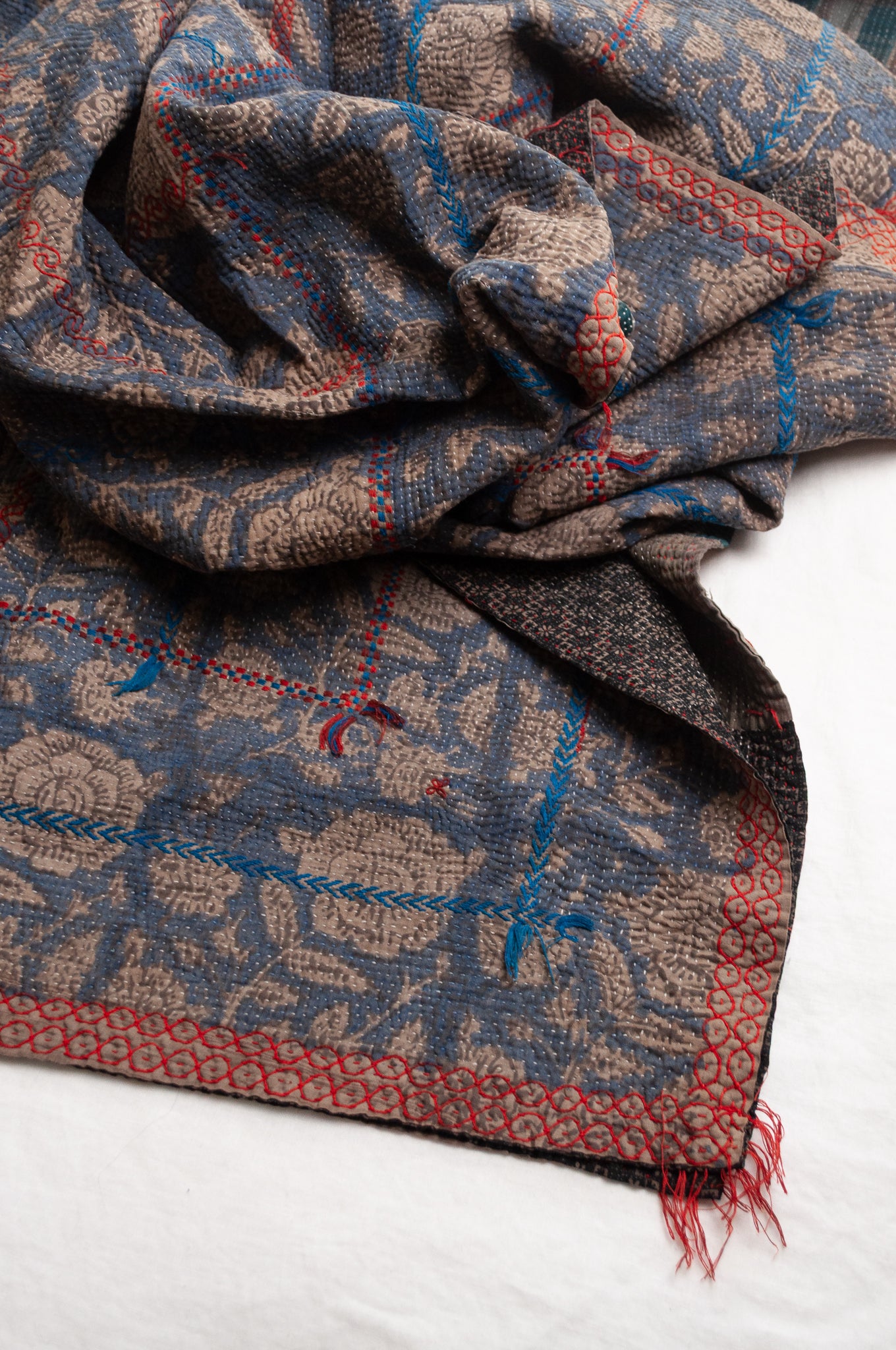 Vintage kantha quilt Bagru blockprinted in indigo floral design with red and cobalt blue embroidery.