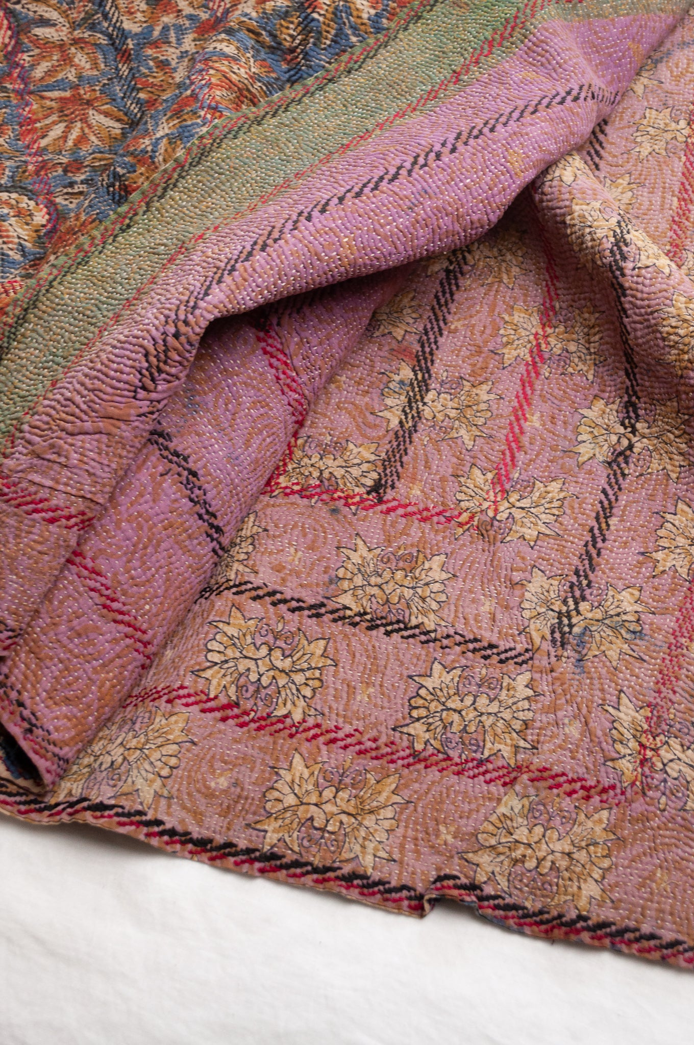 Vintage kantha quilt Bagru blockprinted in indigo, mustard and rust brown, floral design with red and dark green embroidery.