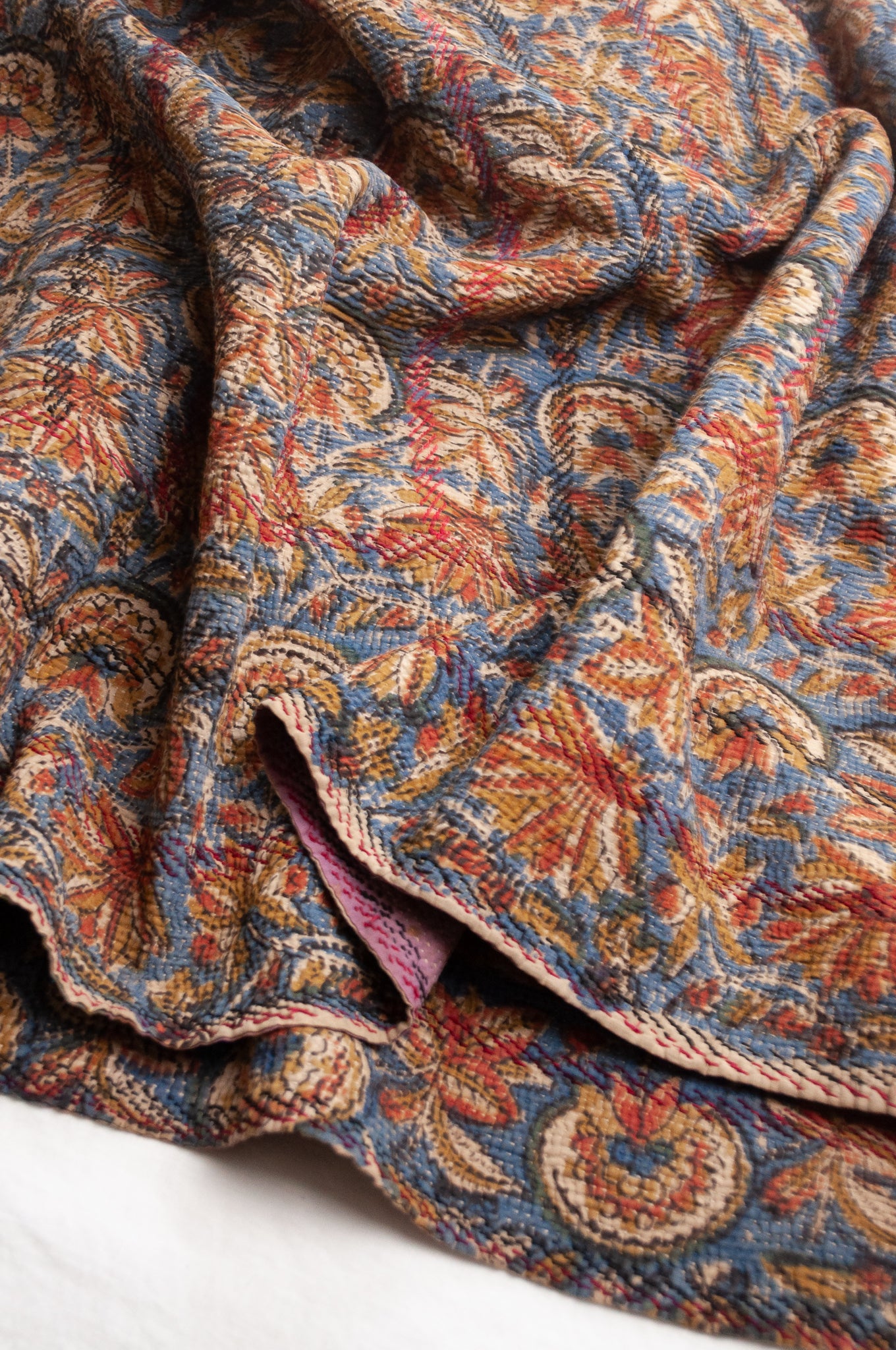 Vintage kantha quilt Bagru blockprinted in indigo, mustard and rust brown, floral design with red and dark green embroidery.