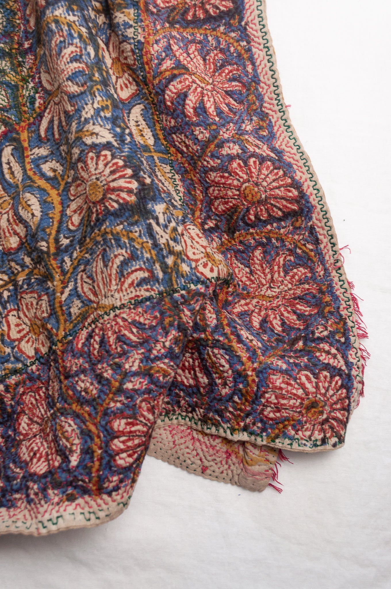 Vintage kantha quilt Bagru blockprinted in indigo and rust brown, floral design with red braid edging embroidery.