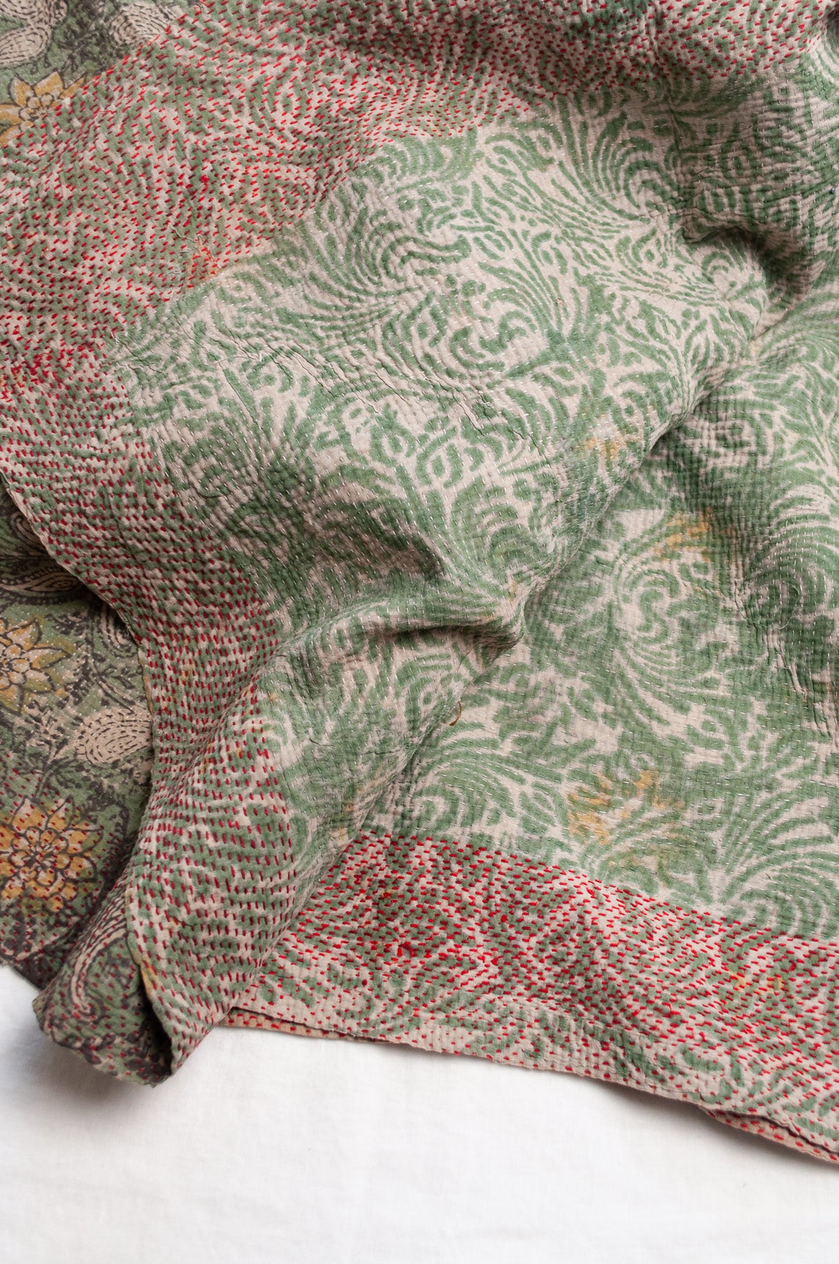 Vintage kantha quilt Bagru blockprinted in sage green, floral design with red braid edging embroidery.