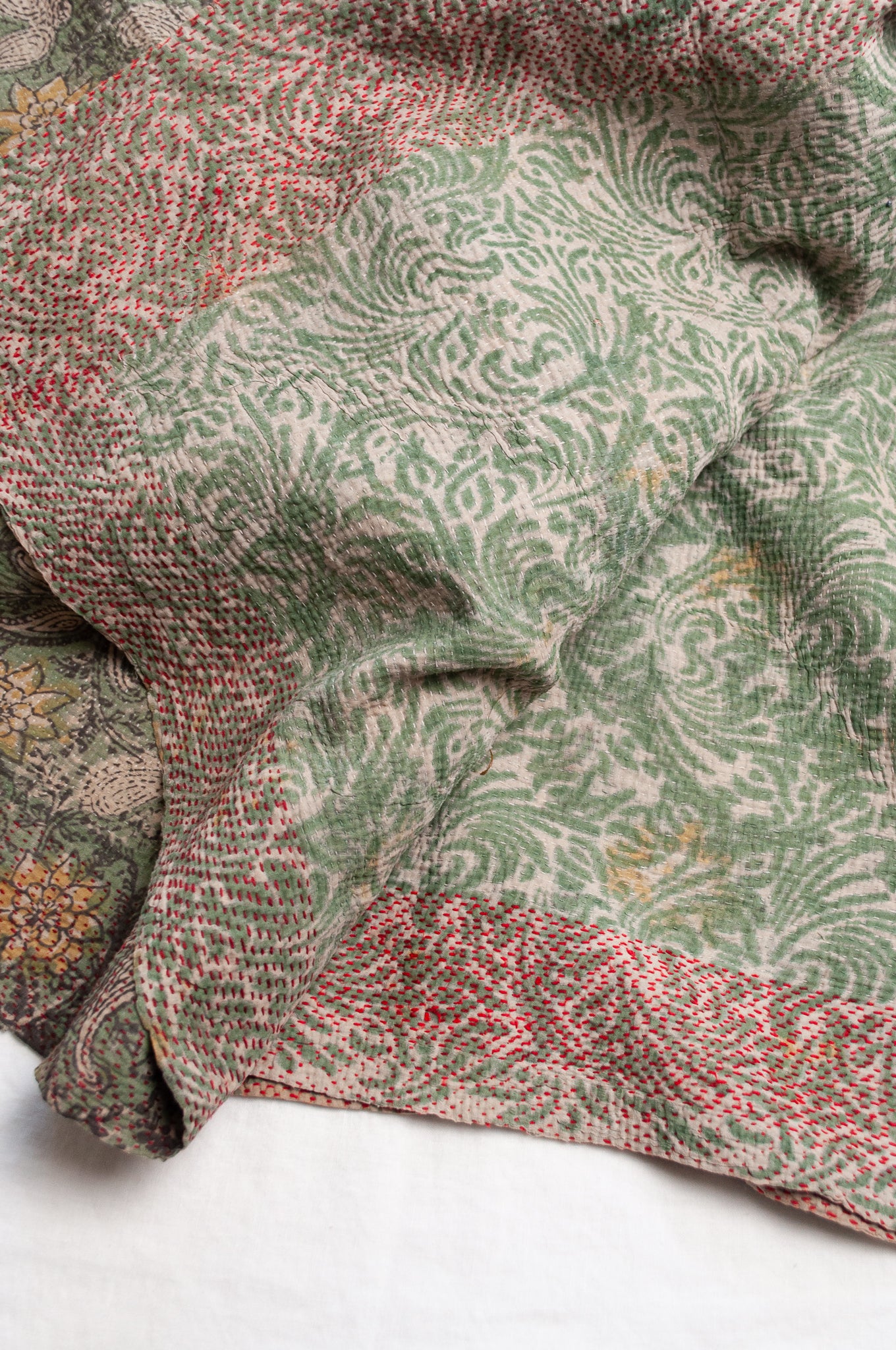Vintage kantha quilt Bagru blockprinted in sage green, floral design with red braid edging embroidery.