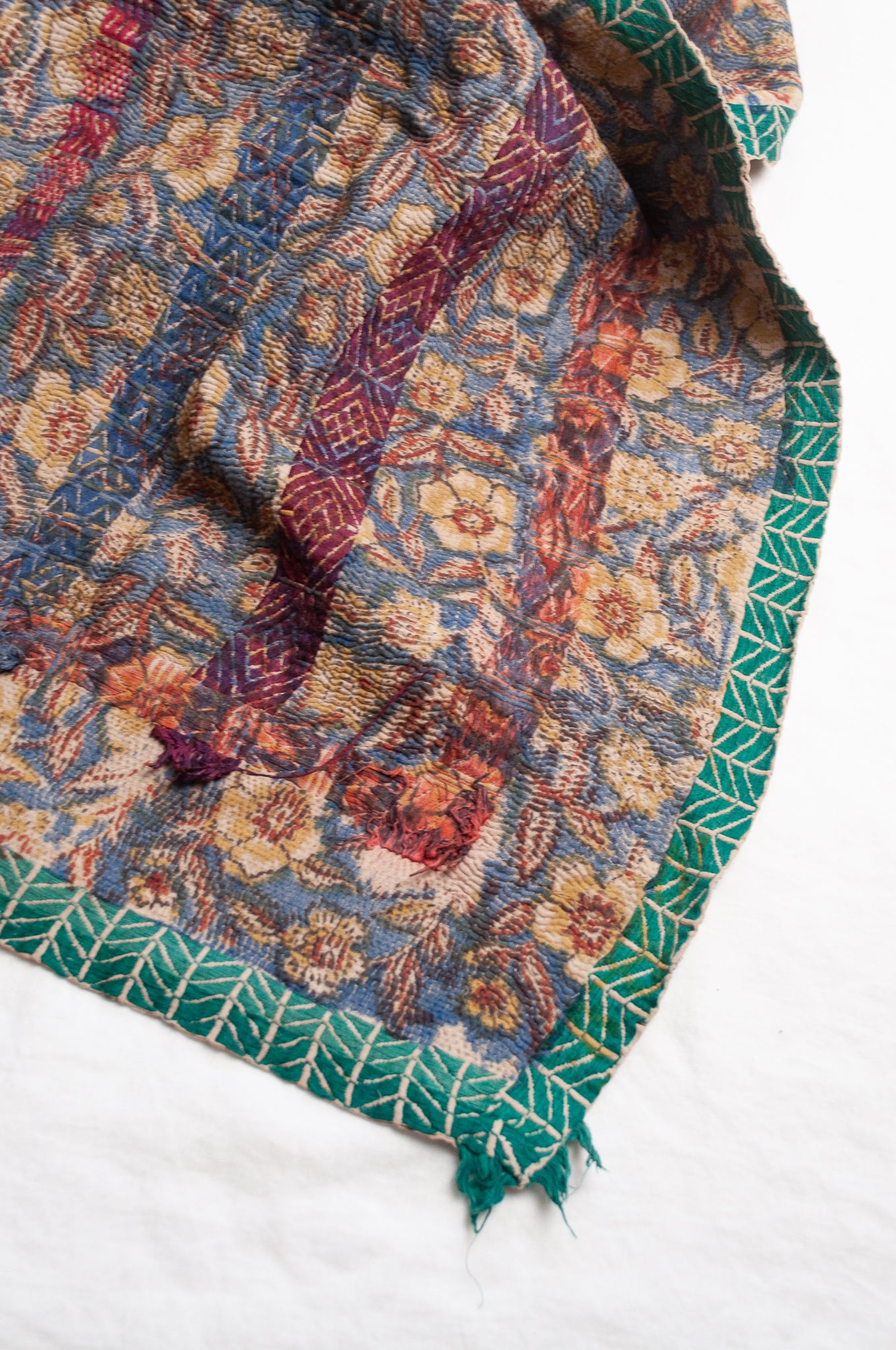 Vintage kantha quilt Bagru blockprinted in indigo, floral design with red, blue and green braid embroidery.