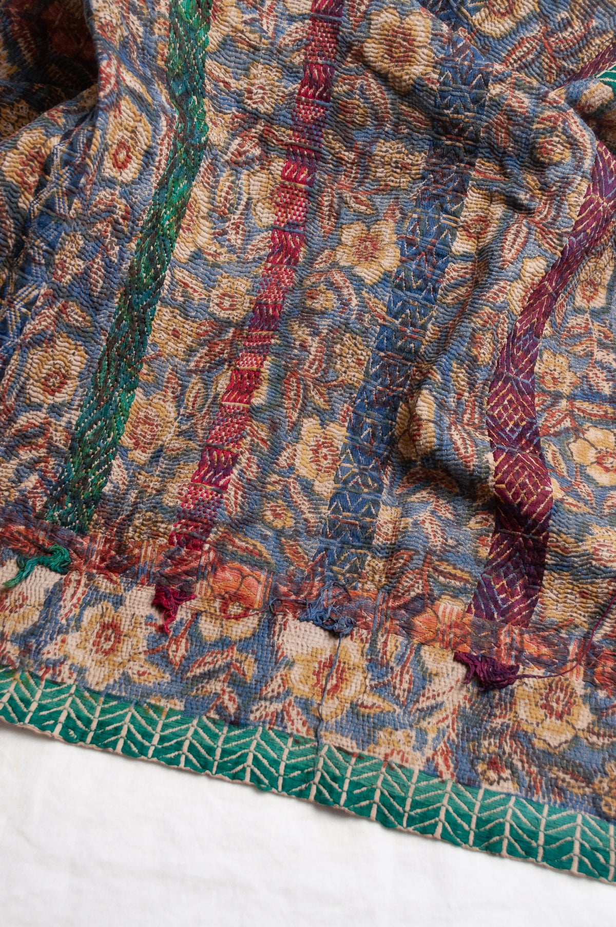 Vintage kantha quilt Bagru blockprinted in indigo, floral design with red, blue and green braid embroidery.