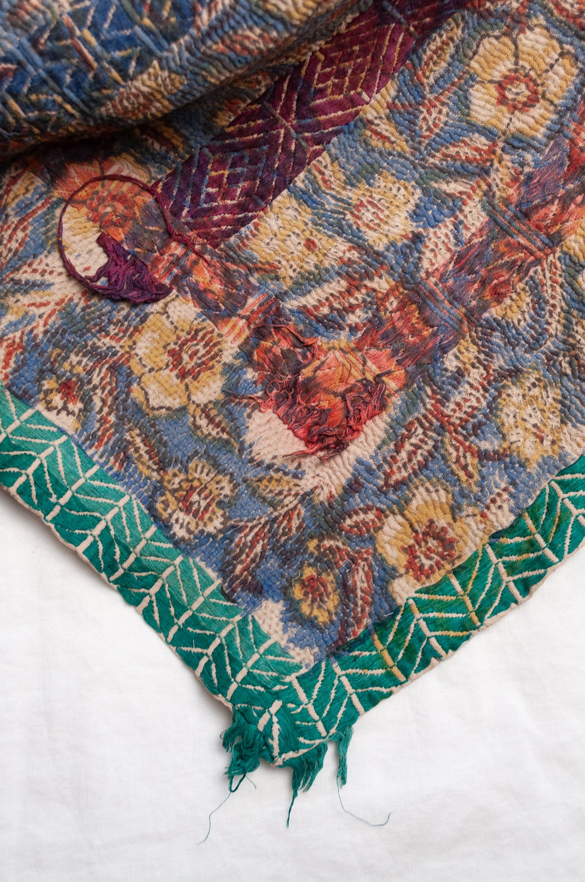 Vintage kantha quilt Bagru blockprinted in indigo, floral design with red, blue and green braid embroidery.