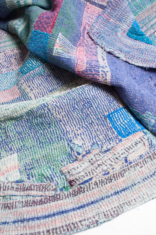 Faded striped kantha quilt in pinks, blues and greens.