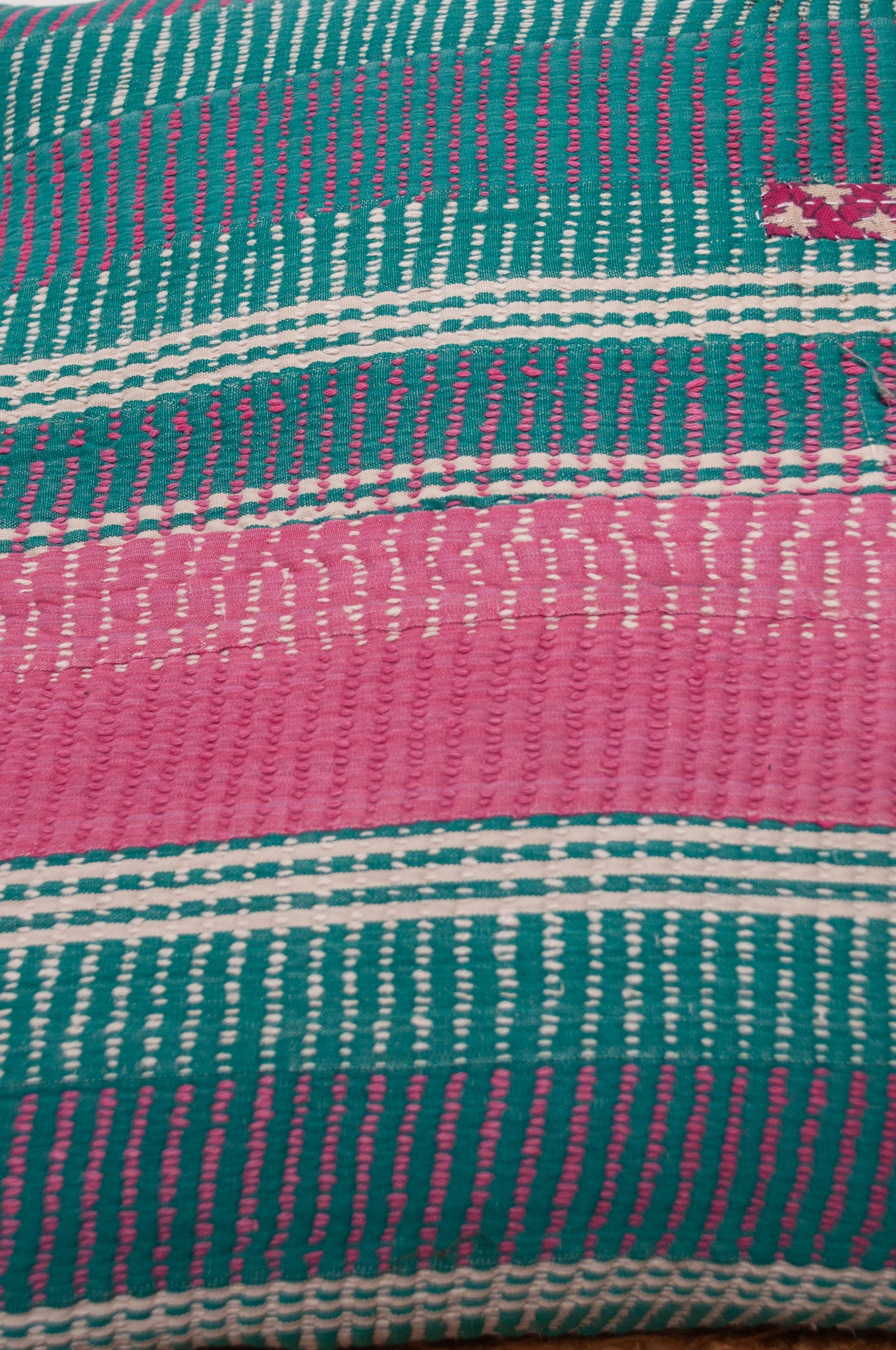 Vintage kantha cushion with stripes in pink, blue and green, finely stitched.