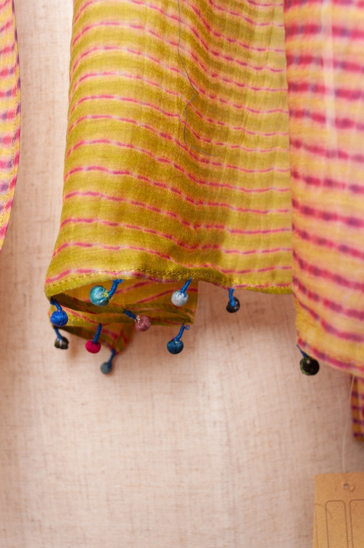 Neeru Kumar shibori dyed cotton silk scarf in raspberry pink and lime, with handmade tiny beads on the ends.