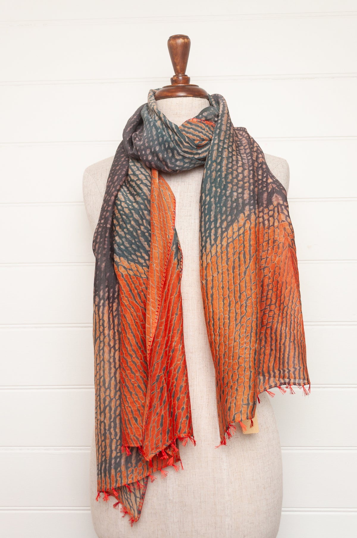 Neeru Kumar shibori dyed cotton silk scarf in charcoal and orange, with handstitched edgings and tiny tassels in red.
