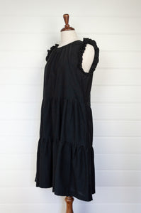 Valia made in Melbourne NYE little black dress in black silk cotton, tiered skirt and ruffles at the shoulder.