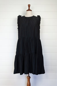 Valia made in Melbourne NYE little black dress in black silk cotton, tiered skirt and ruffles at the shoulder.