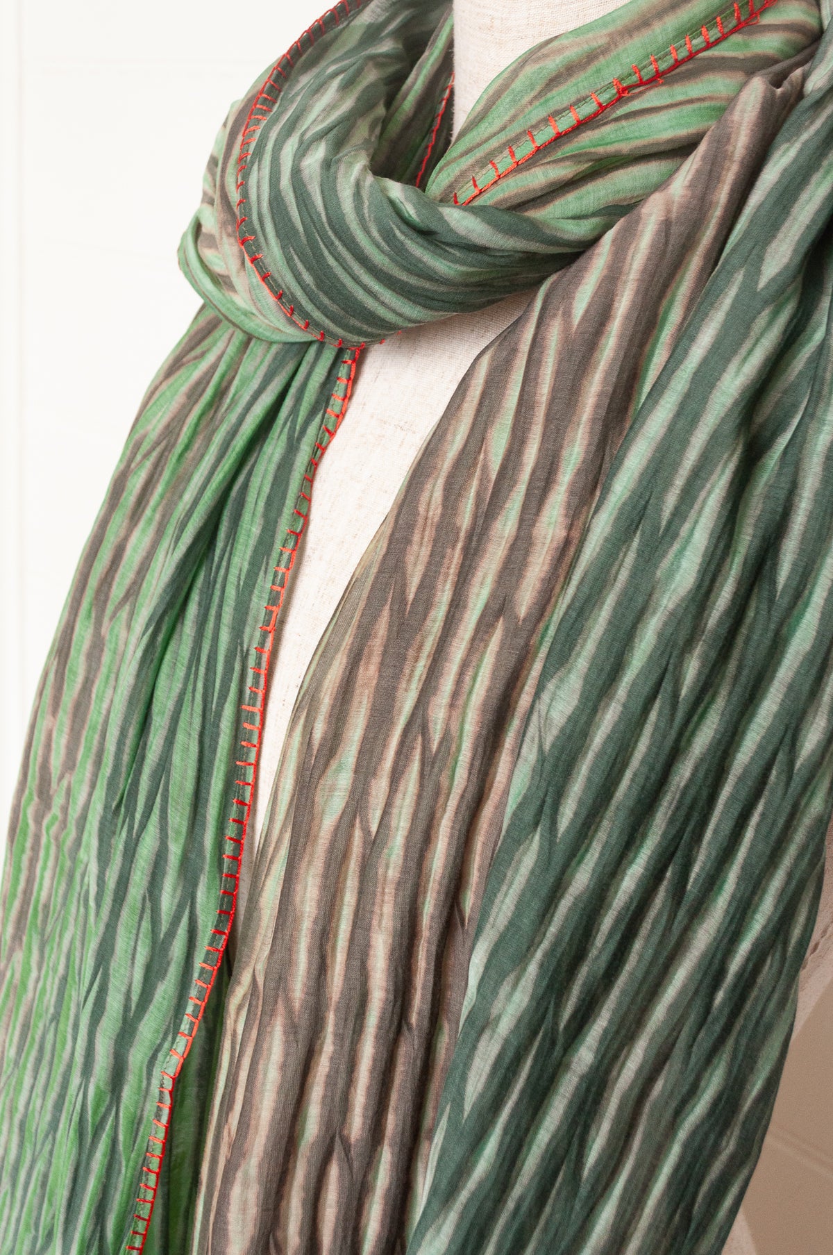 Neeru Kumar shibori dyed cotton silk scarf in shades of green, with handstitched edgings and tiny tassels in red.