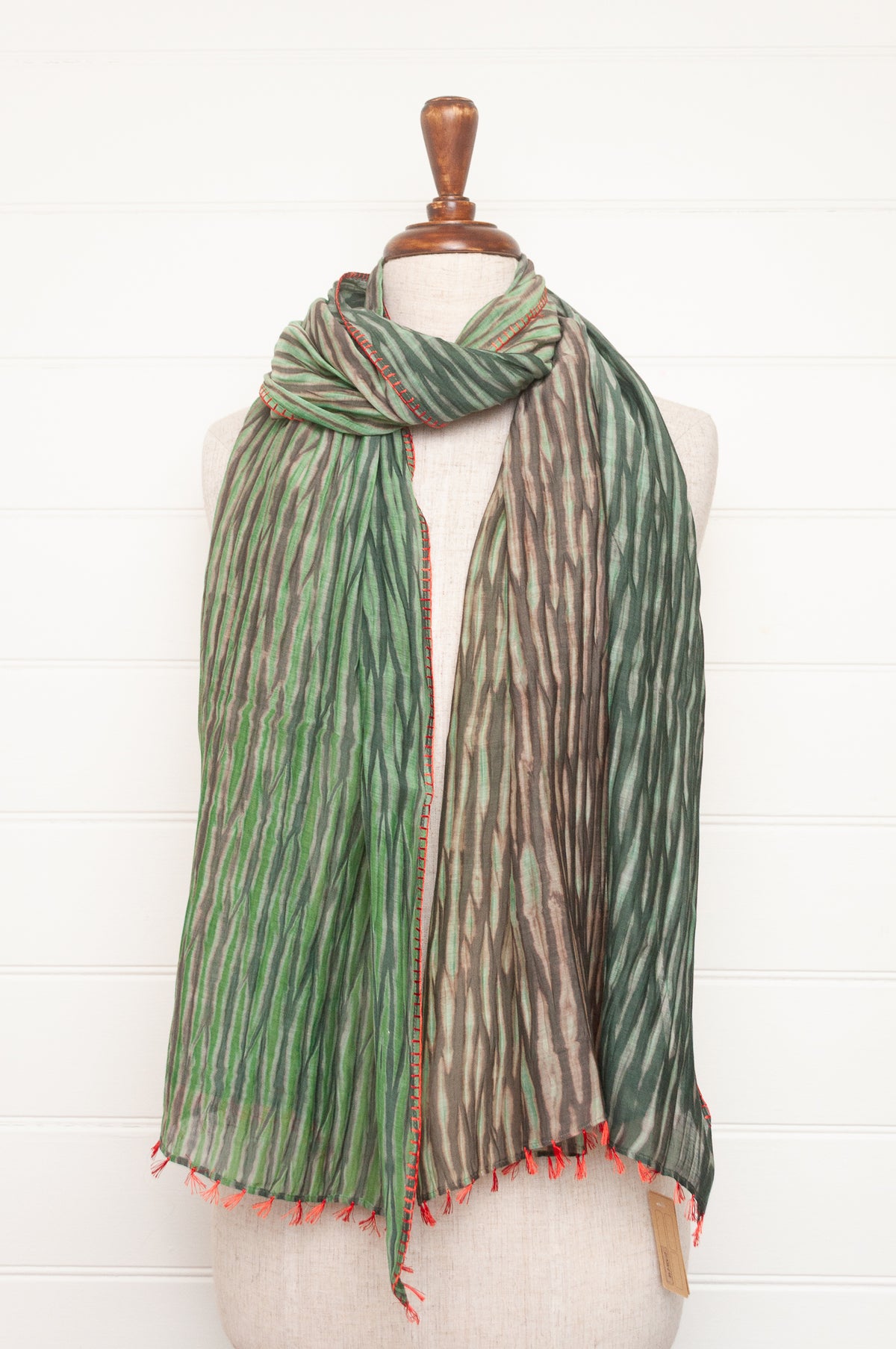 Neeru Kumar shibori dyed cotton silk scarf in shades of green, with handstitched edgings and tiny tassels in red.