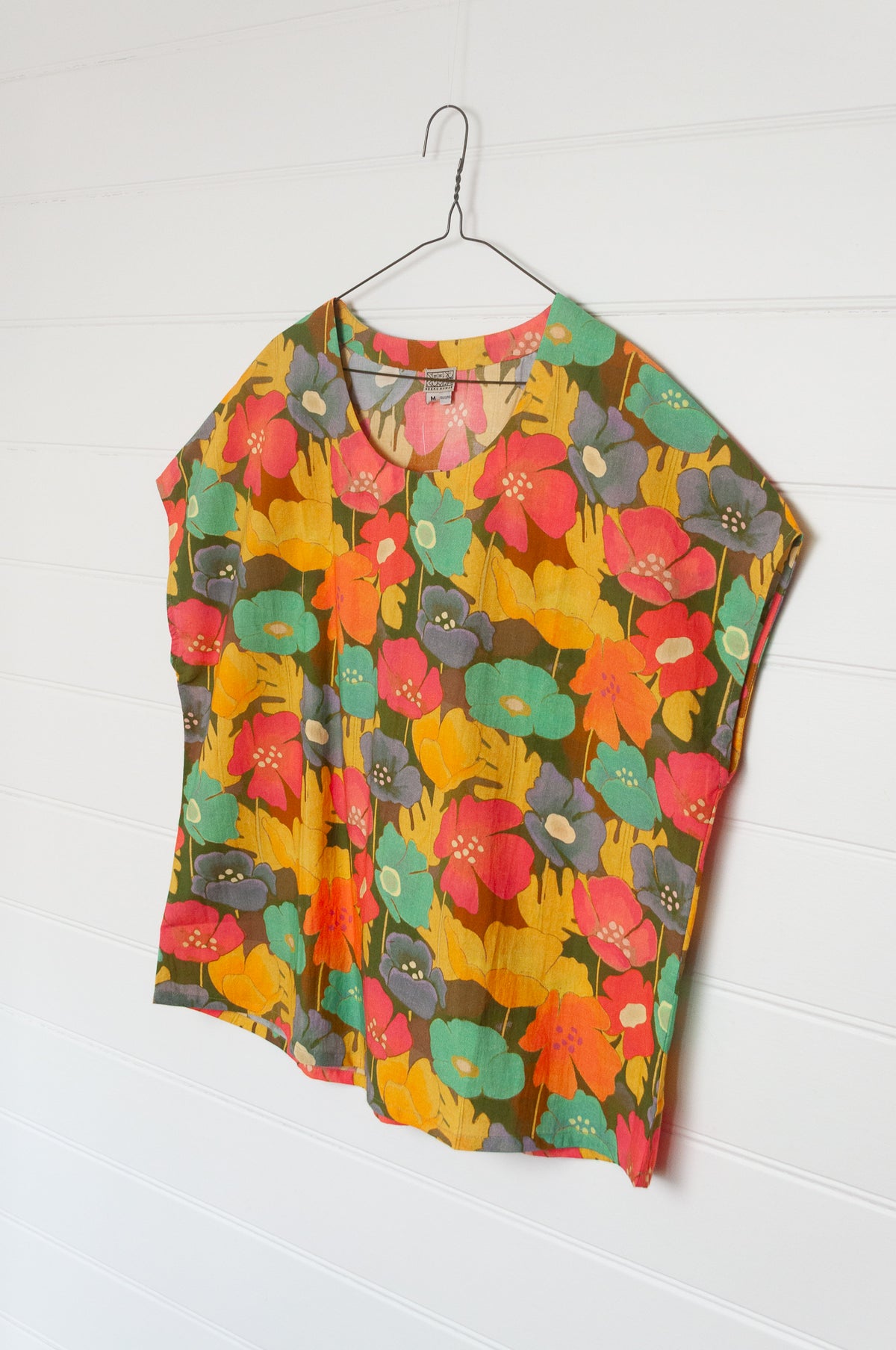 Neeru Kumar round neck cap sleeve top with a colorful floral pattern.