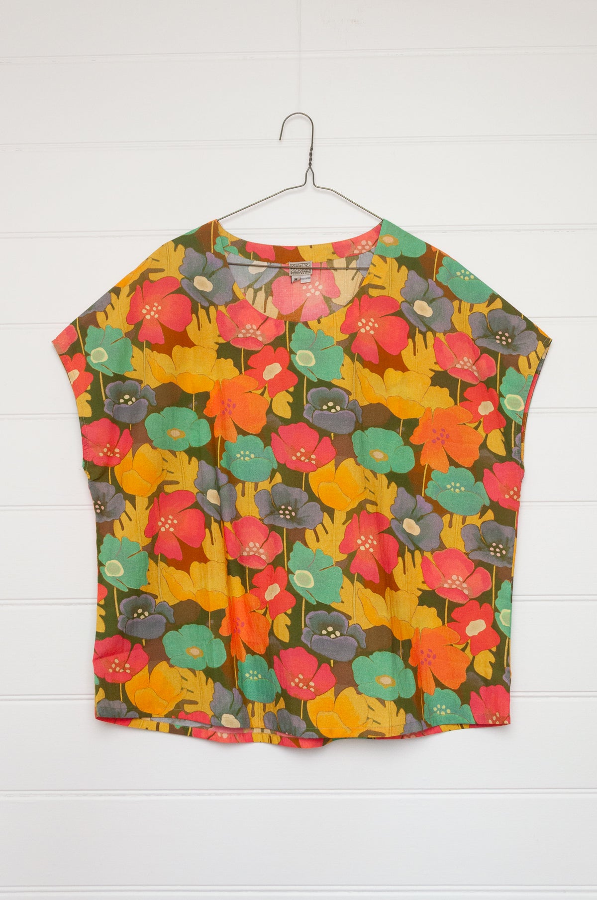 Neeru Kumar round neck cap sleeve top with a colorful floral pattern.