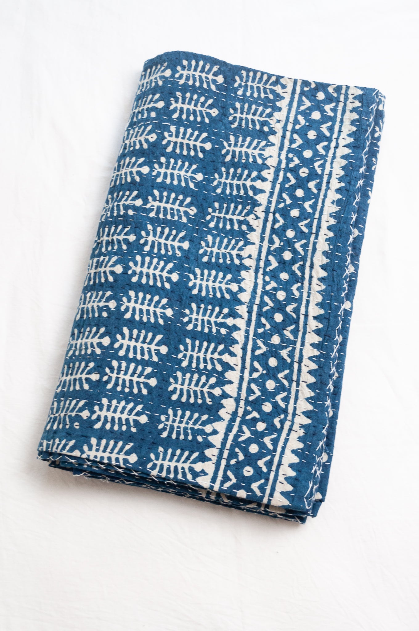 Indigo blue and white pure cotton kantha stitch bed quilt with fern design.